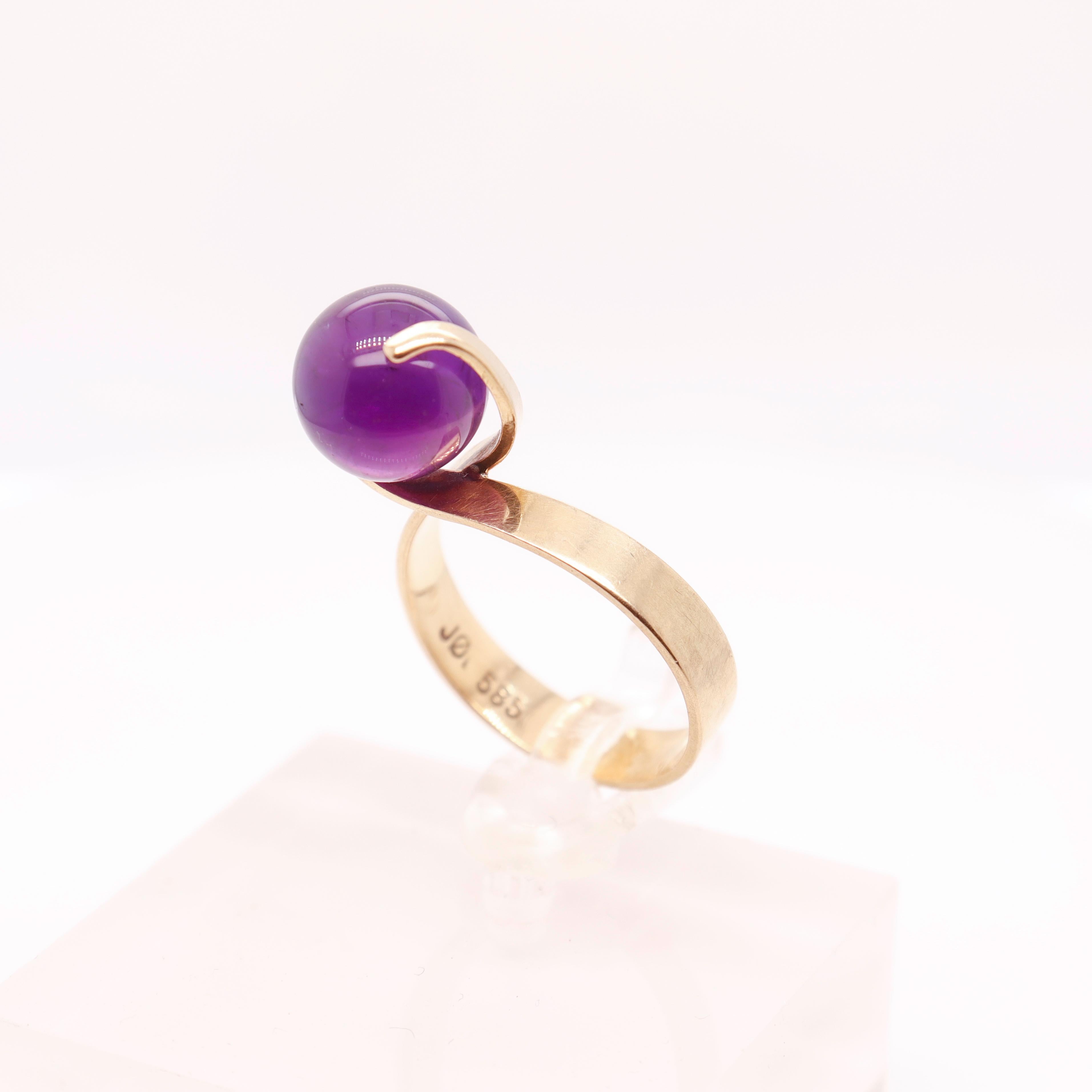 A fine signed Danish modern gold & amethyst ring 

In 14k gold.

By Jørgen Larsen.

With a spherical amethyst gemstone bead. We believe this ring is meant to hold any spherical gemstone bead of the same size (10mm).

Simply wonderful Danish Modern