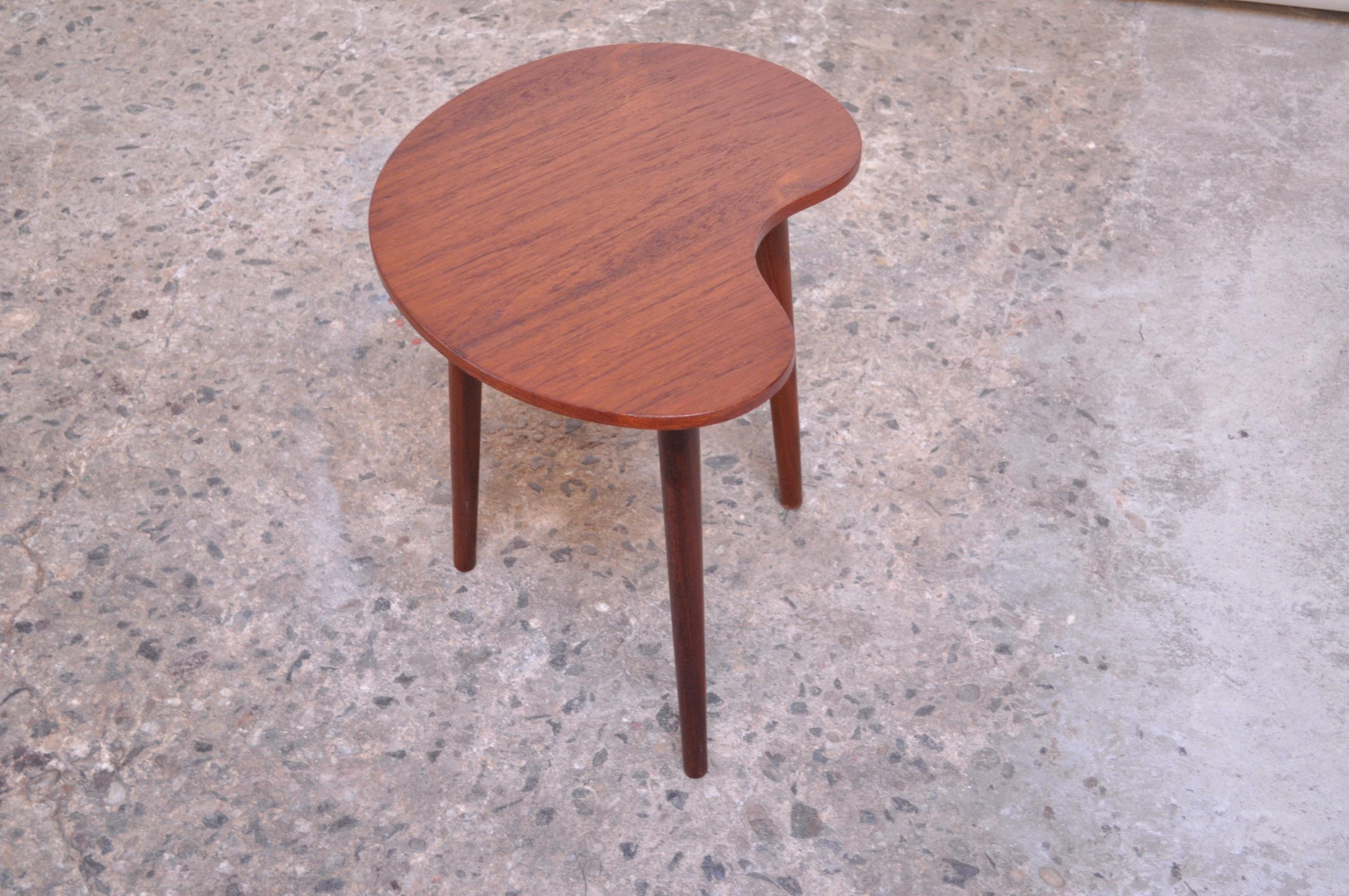 Teak side table by Gorm-Møbler of Denmark, circa 1955. Features a 'kidney' / organic form top supported by three sculptural, tapered legs. Newly refinished condition; only light wear remains. 

Measures: H 17.1