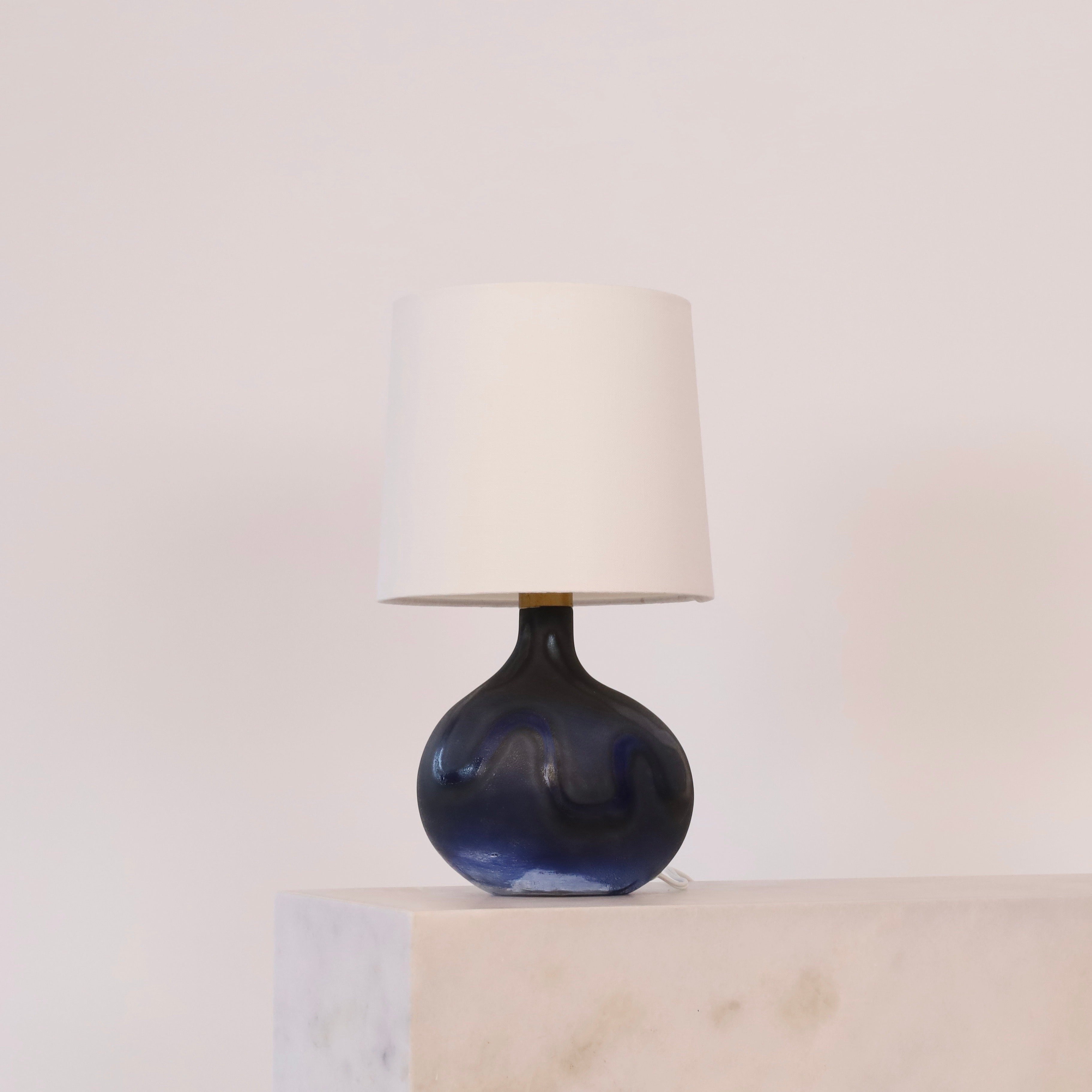 A Modern Lamp Art glass desk lamp in organic shaped designed by Michael Bang in 1972 for Holmegaard, Denmark. Irresistible to eye.

* A blue patterned mouth-blown organic glass table lamp with a white fabric shade
* Designer: Michael Bang 
* Style: