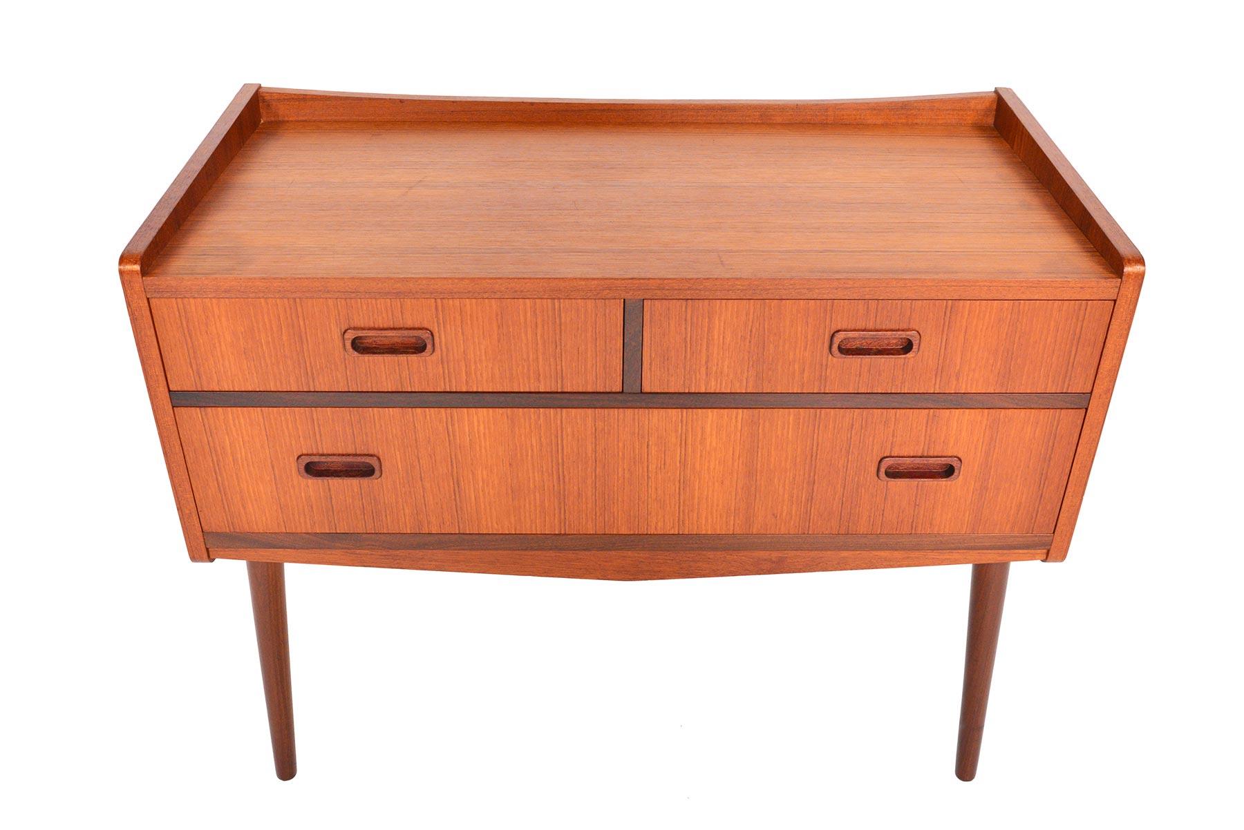 Wide and tall, this Danish modern teak chest offers an unusual footprint perfect for modern interiors! Banding and pulls are crafted from beautifully contrasting afromosia. Three drawers sit an atomic case and stand on canted legs. In excellent