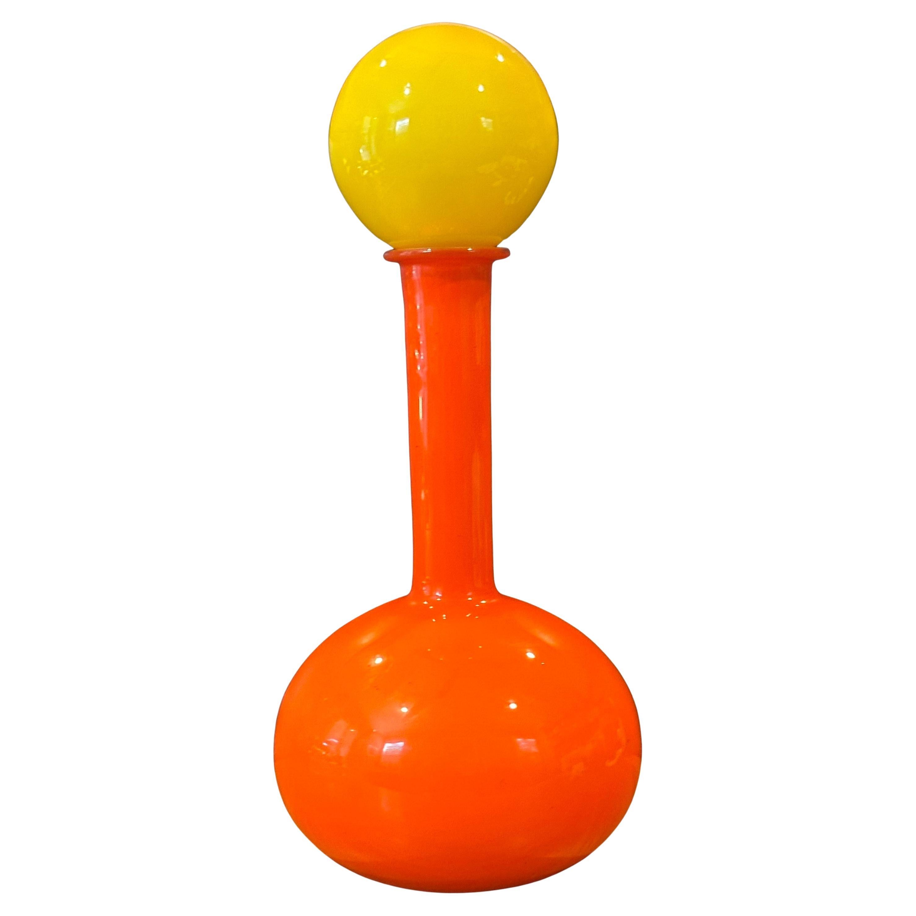 Iconica bottiglia moderna danese in vetro artistico soffiato a mano con tappo in uno splendido contrasto arancione e giallo, realizzata da Otto Brauer per Holmegaard, intorno agli anni '60.  Si tratta di una dimensione molto rara, la forma e la