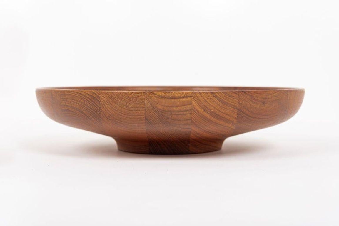 This iconic and rare vintage mid century Danish modern teak wood bowl was designed by Henning Koppel, produced by Georg Jensen, and made in Denmark circa 1960. This large decorative bowl has a classic Scandinavian modern aesthetic with clean,