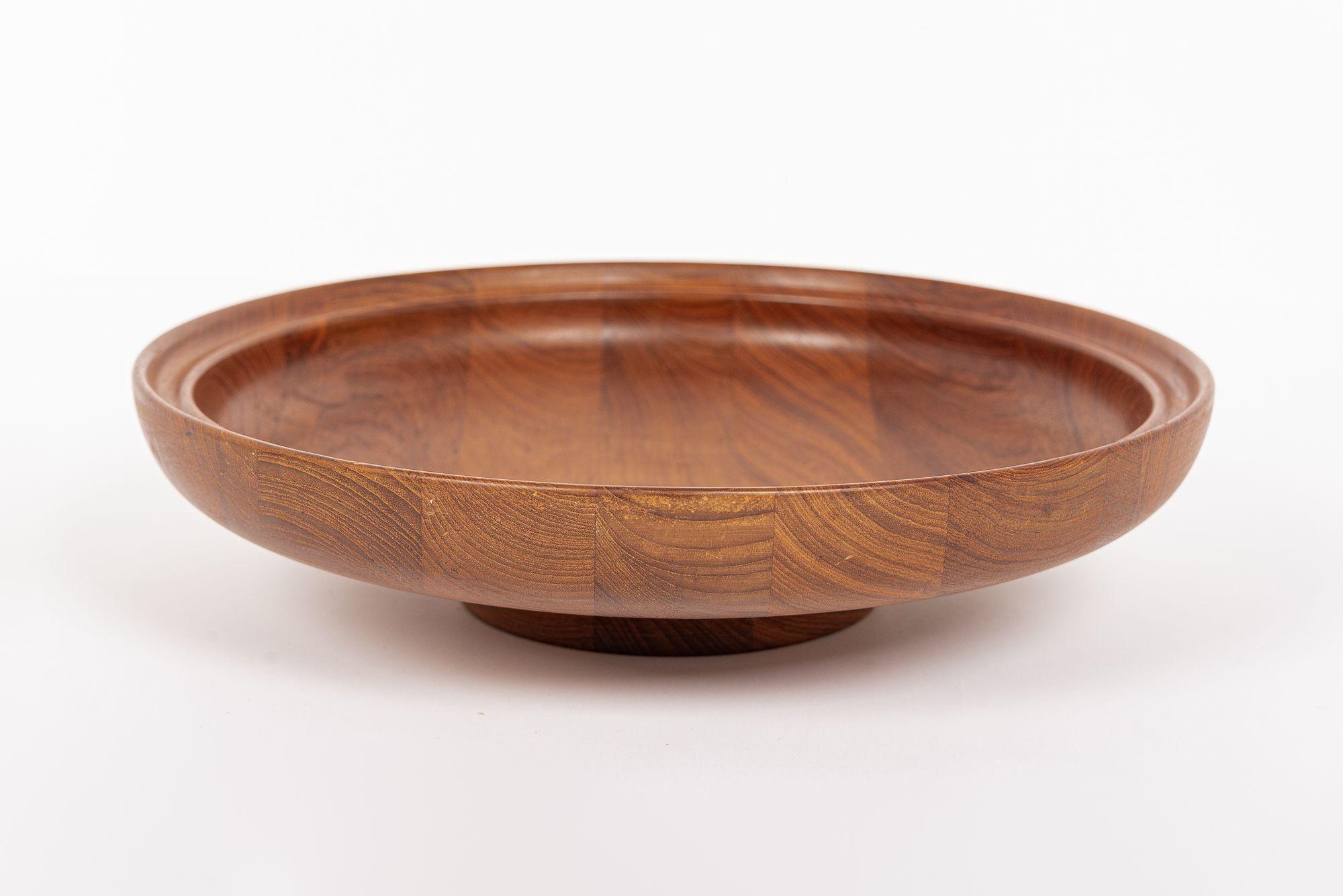 This rare and iconic vintage mid century Danish modern teak wood bowl was designed by Henning Koppel and produced by Georg Jensen and made in Denmark circa 1960. This large decorative bowl has a classic Scandinavian modern aesthetic with clean,