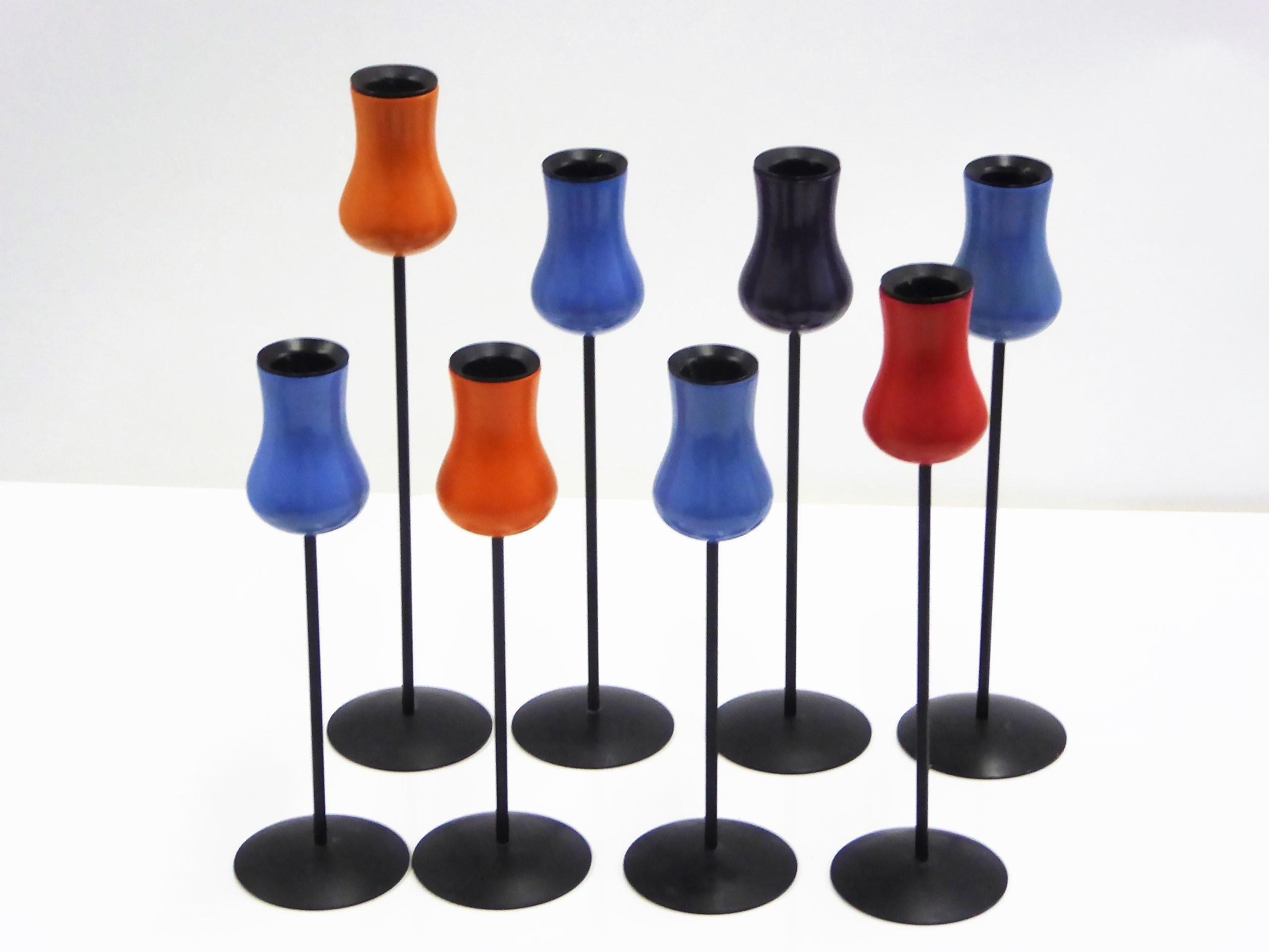 From Denmark, this midcentury Danish Modern grouping of 8 tulip shaped candlesticks by Laurids Lonborg in lacquered wood and metal bases. Three different heights and four different colors, blue, deep purple, orange and red. A few small paint