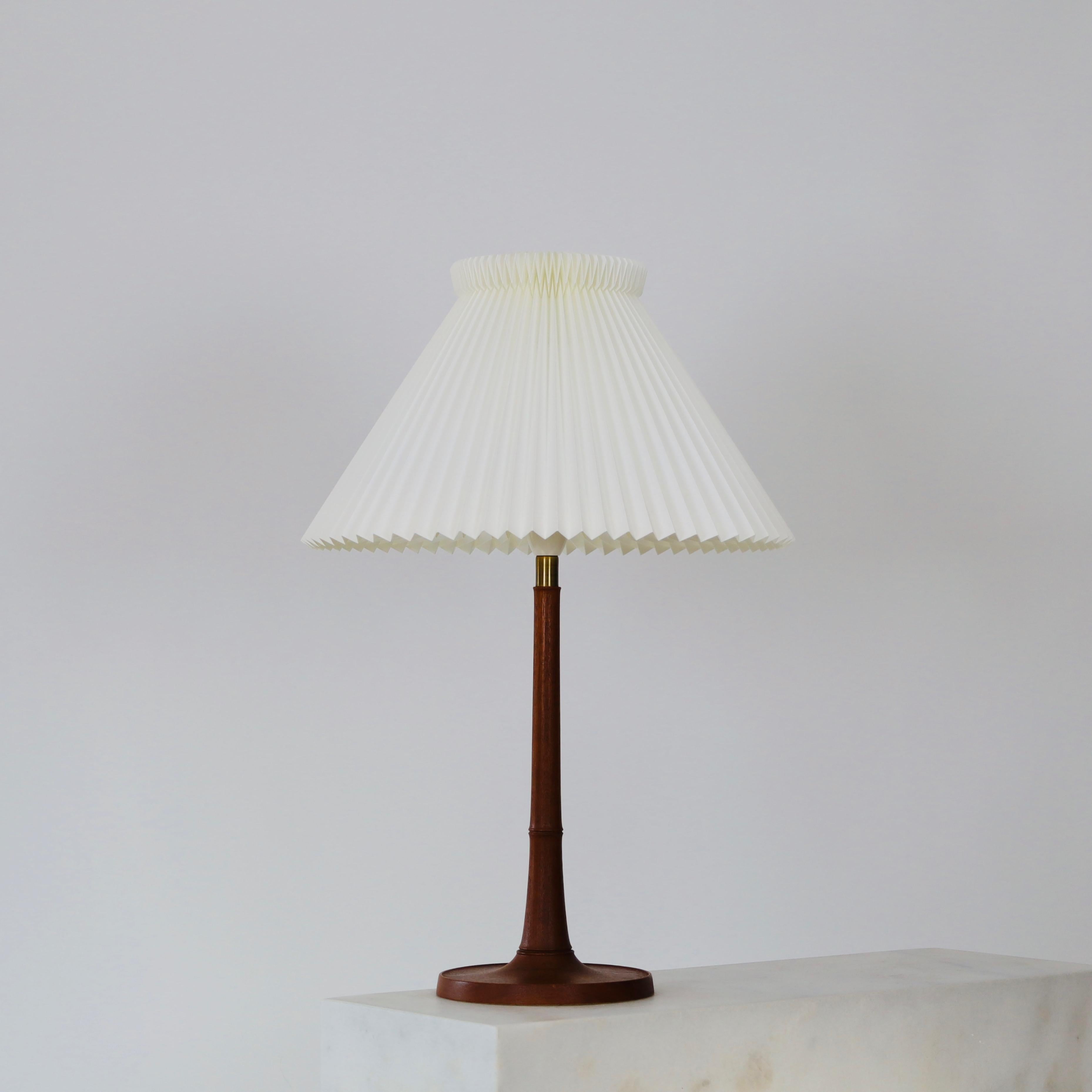 An oak wood table lamp in excellent vintage condition designed by Esben Klint in 1957 for Le Klint. It has a beautiful dark patina and is rare piece for a beautiful space.  

* An dark oak wood table lamp with a hand-pleated shade
* Designer: Esben