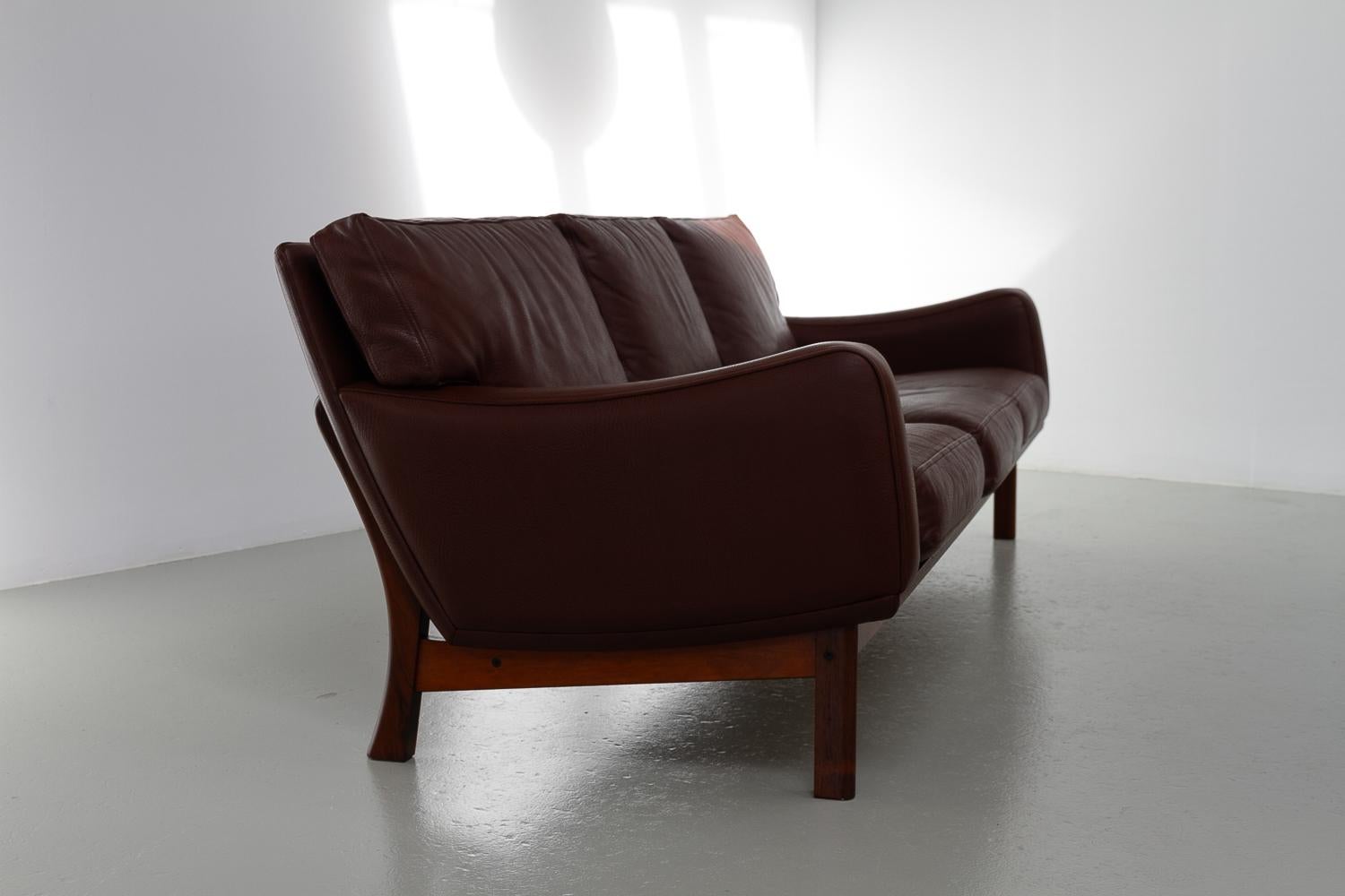 Danish Modern Leather and Rosewood Sofa by Eran, 1960s.
Fantastic Scandinavian Mid-Century Modern large three-seater sofa designed and manufactured by Erhardsen & Andersen (Eran) Denmark in the late 1960s.

This model was top of line from Eran, made