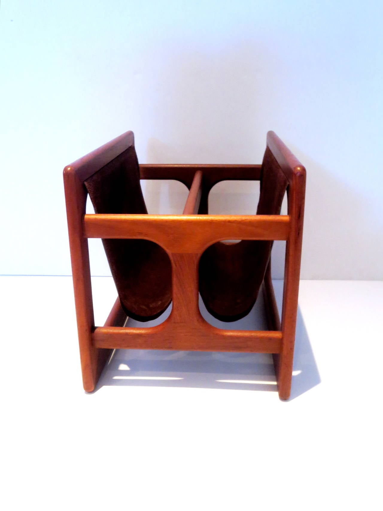 A very rare and beautiful Danish modern chocolate leather and teak sculpted double magazine rack, circa 1970s. The magazine rack is super high quality and in very good vintage condition; it measures 20.5