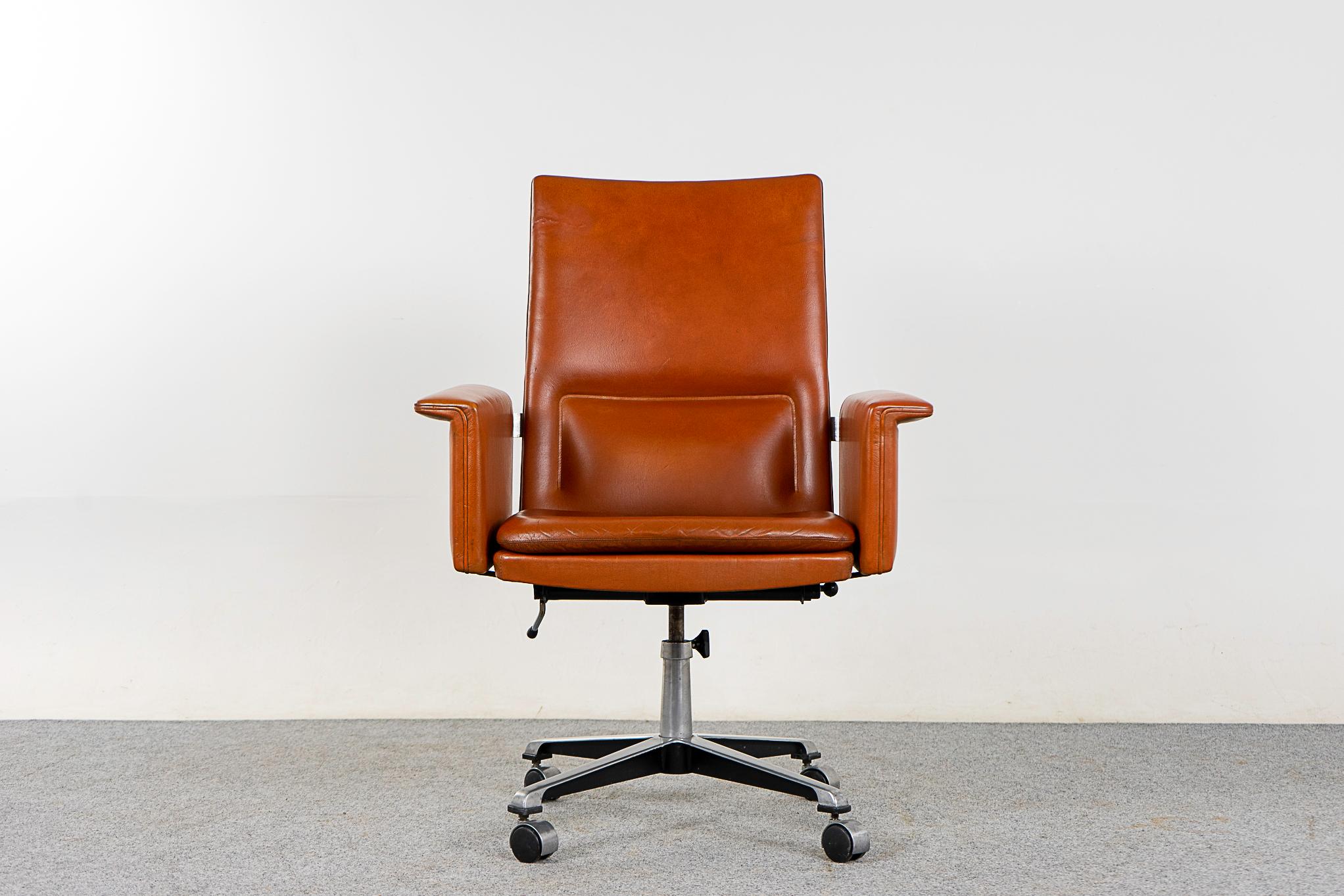 Leather and chrome Danish swivel chair, circa 1960's. Original rust colored leather with beautiful angles and excellent lumbar support. Shining metal base with smooth operating castors. Minor repair on leather. Work in style! 

Please inquie for