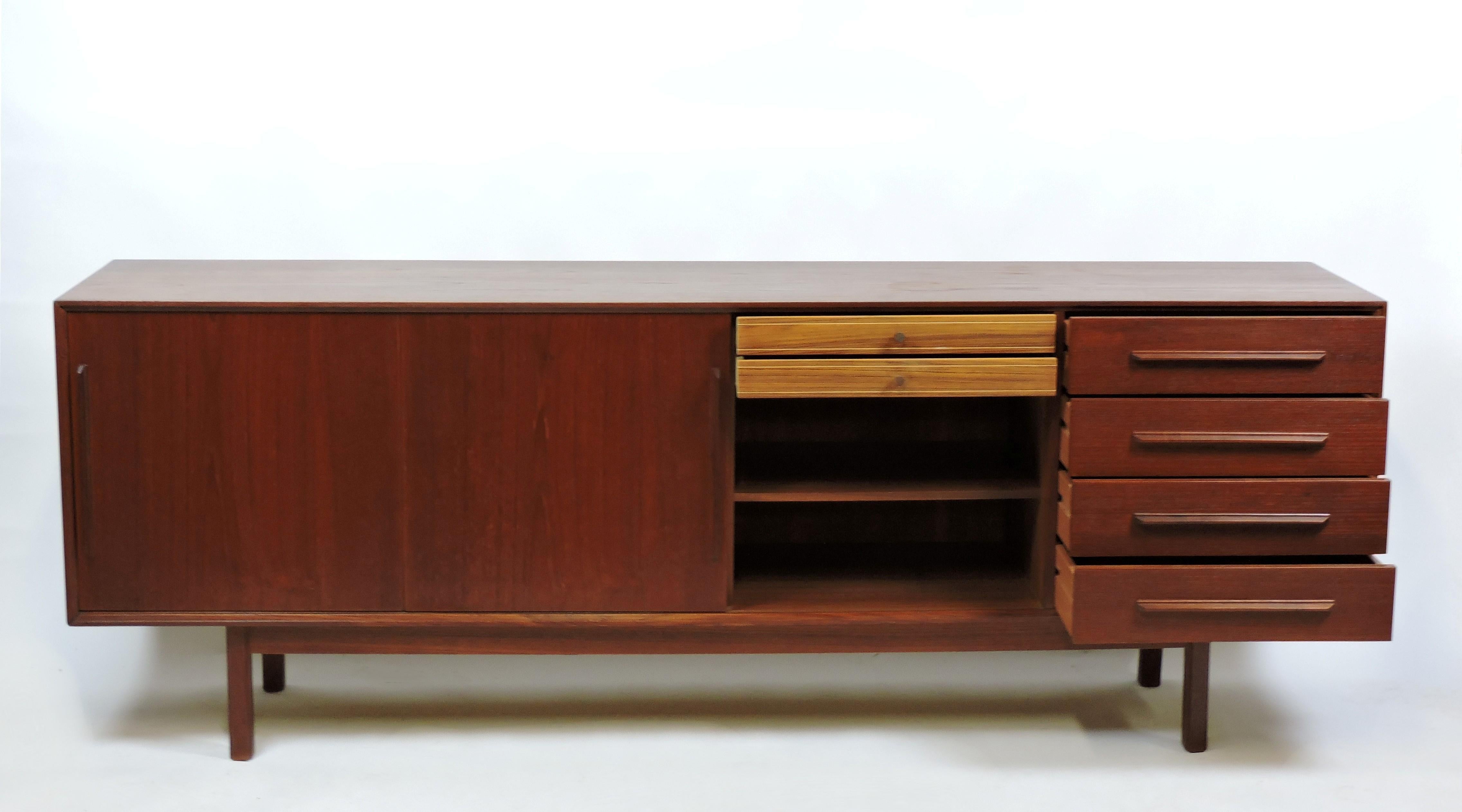 Beautiful and long Danish modern teak credenza made in Denmark and imported by high-end NYC retailer, Maurice Villency. This credenza is almost 7 feet long and has 4 exterior, 2 interior drawers, 3 sliding doors, and 3 adjustable shelves for lots of