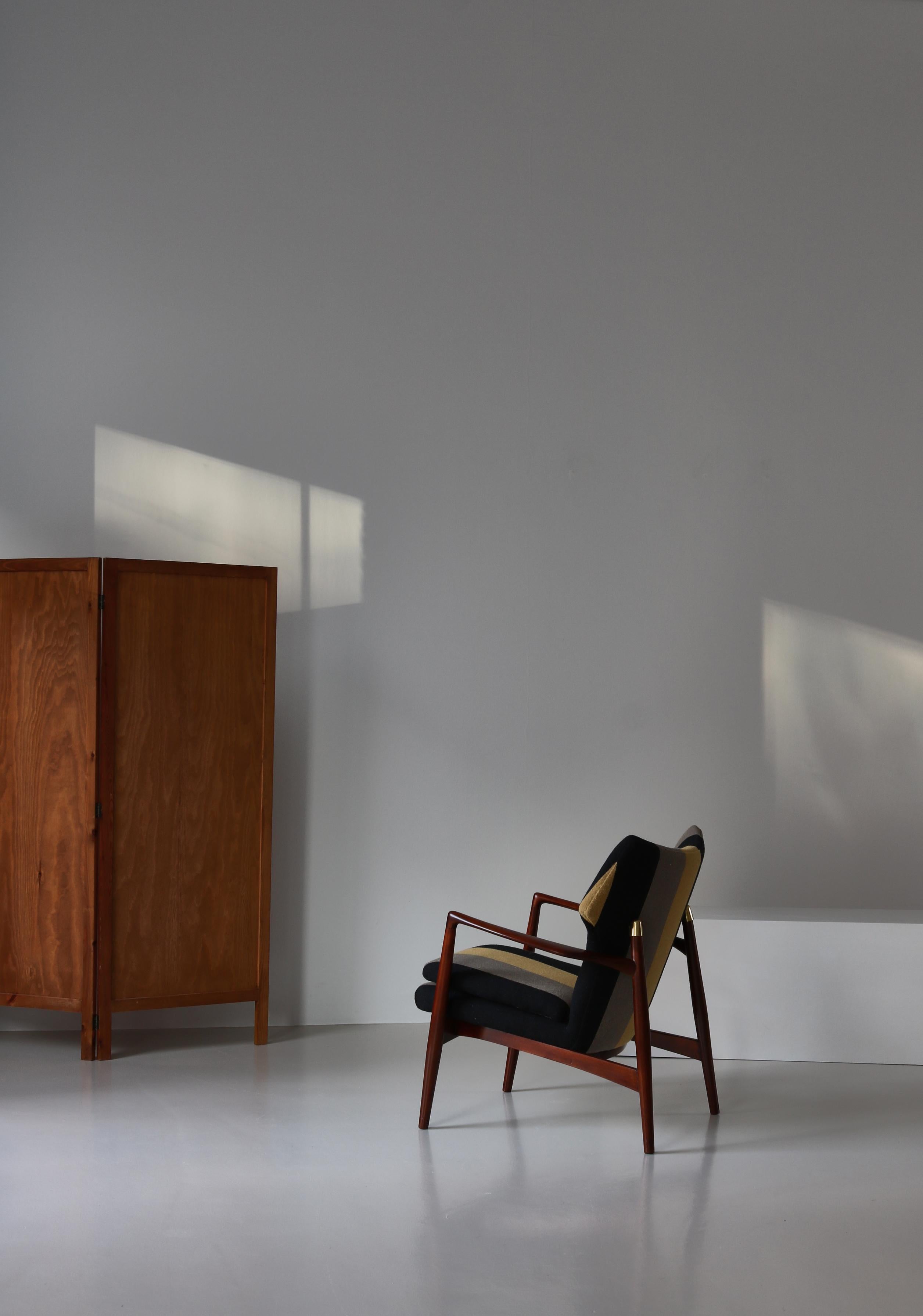 Seltener Sessel der dänischen Architekten Eva & Nils Koppel aus den frühen 1950er Jahren, hergestellt von Johannes Larsen. Der Stuhl ist aus massiver, gebeizter Buche gefertigt und wurde mit einem in Dänemark von Kjellerup-Webern handgefertigten