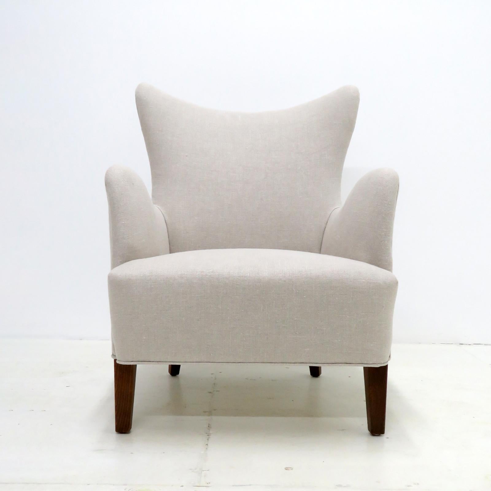 Magnifique chaise longue moderne danoise conçue par Frode Holm pour Illums Bolighus, années 1940, pieds en hêtre teinté foncé avec un tissu en lin nouvellement tapissé. Marqué d'une étiquette en papier.