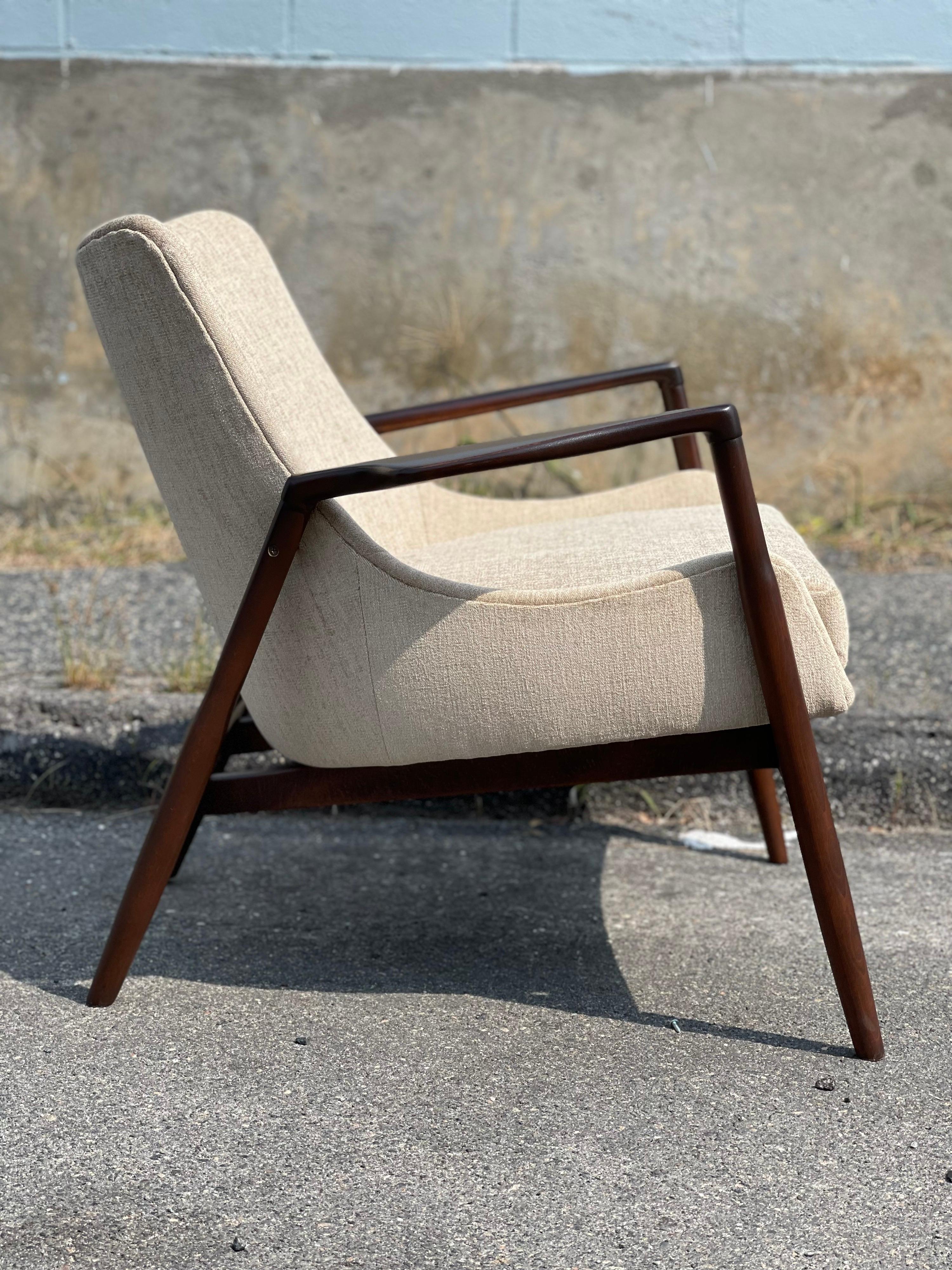 Classic eye-catching Danish Modern Seal style lounge chair by Ib Kofod-Larsen for Selig. This version of this chair is my favorite because of the wide flared armrests. Made of Beech and fabric. The frame has been restored. The seat has new