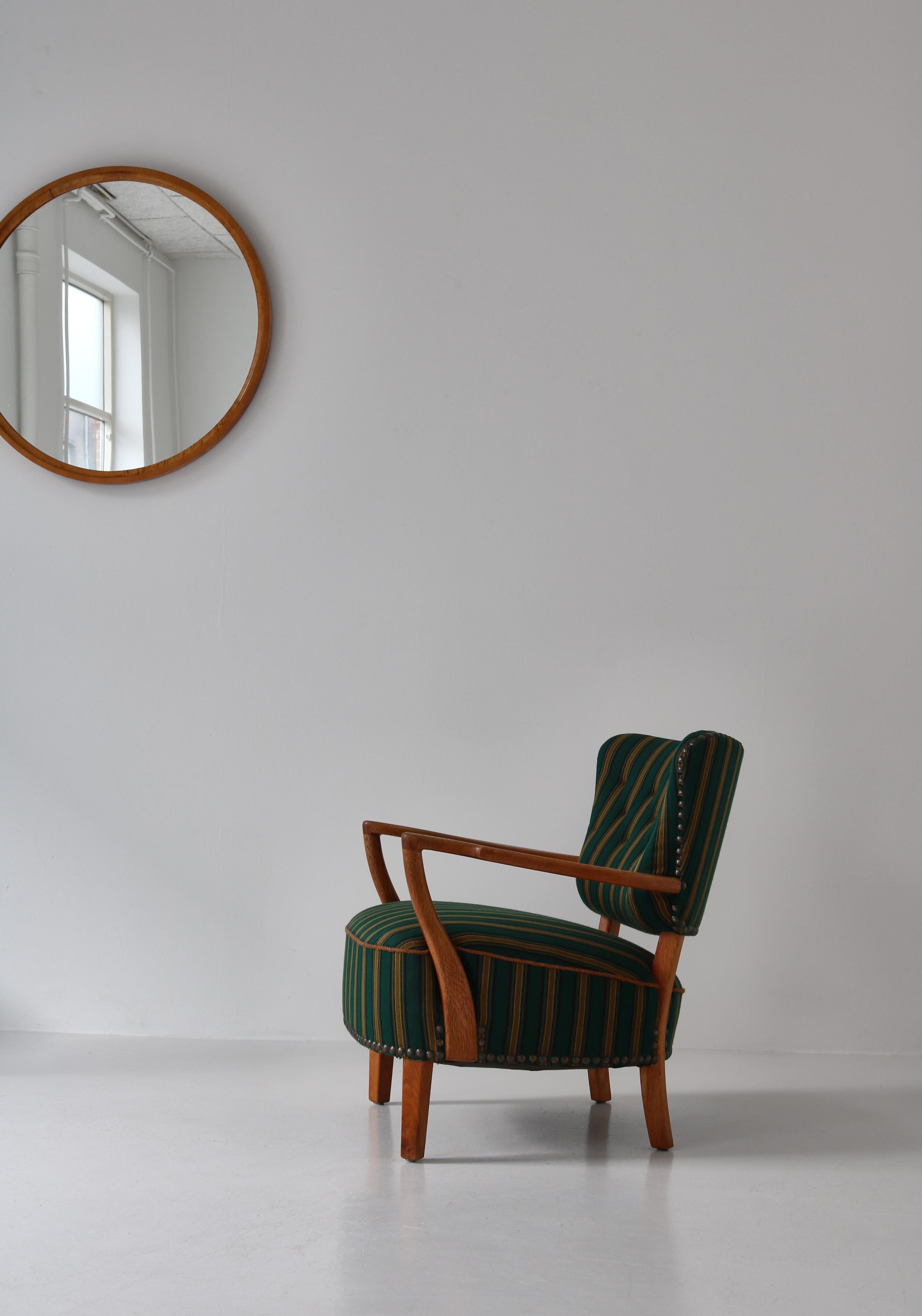 Merveilleuse grande chaise de salon moderne danoise fabriquée à la main par un ébéniste au Danemark dans les années 1950. Des angles et des proportions spectaculaires avec des accoudoirs en bois sculpté et des pieds en chêne massif présentant un