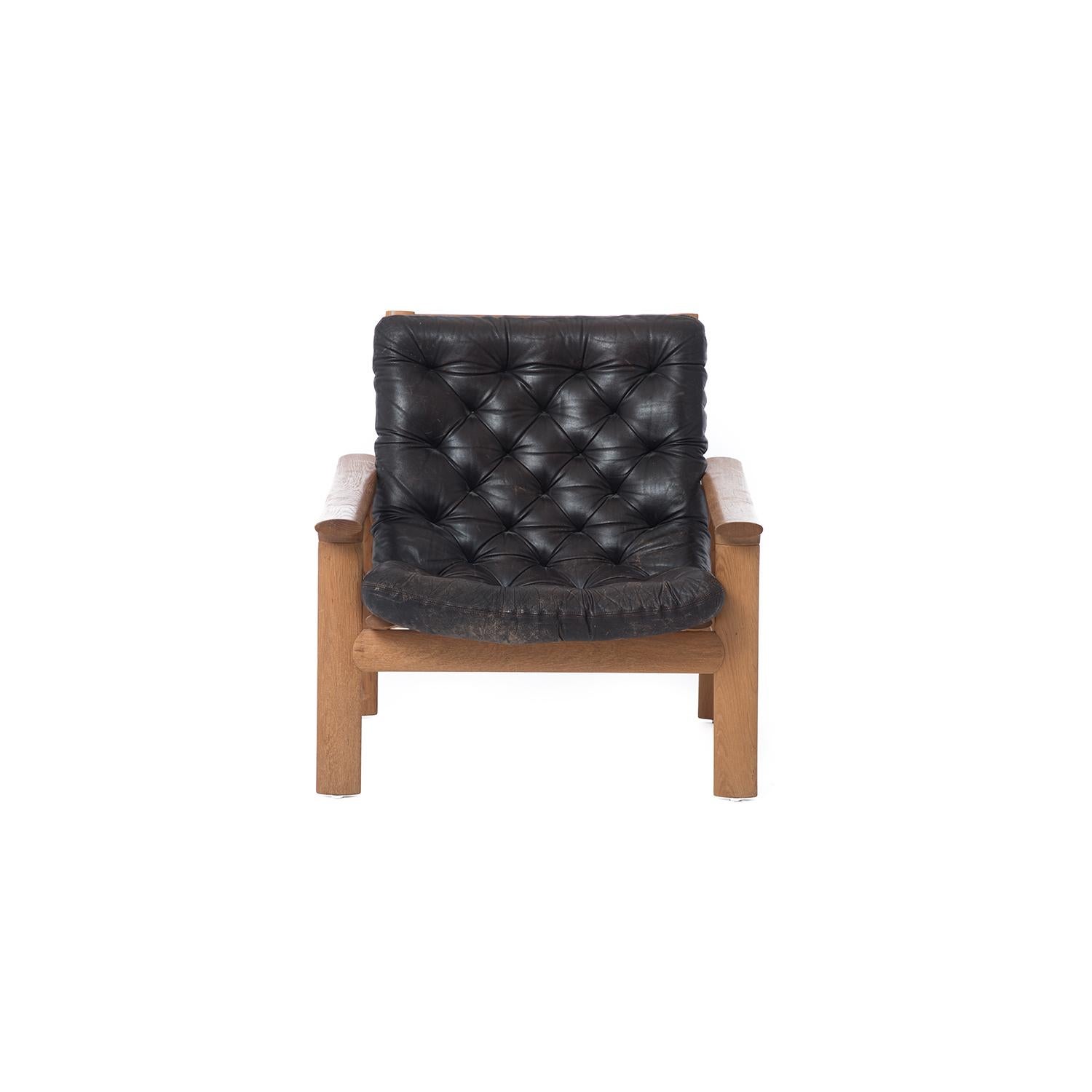 These low-profile oak lounge chairs feature dark brown tufted leather upholstery. Sold separately.