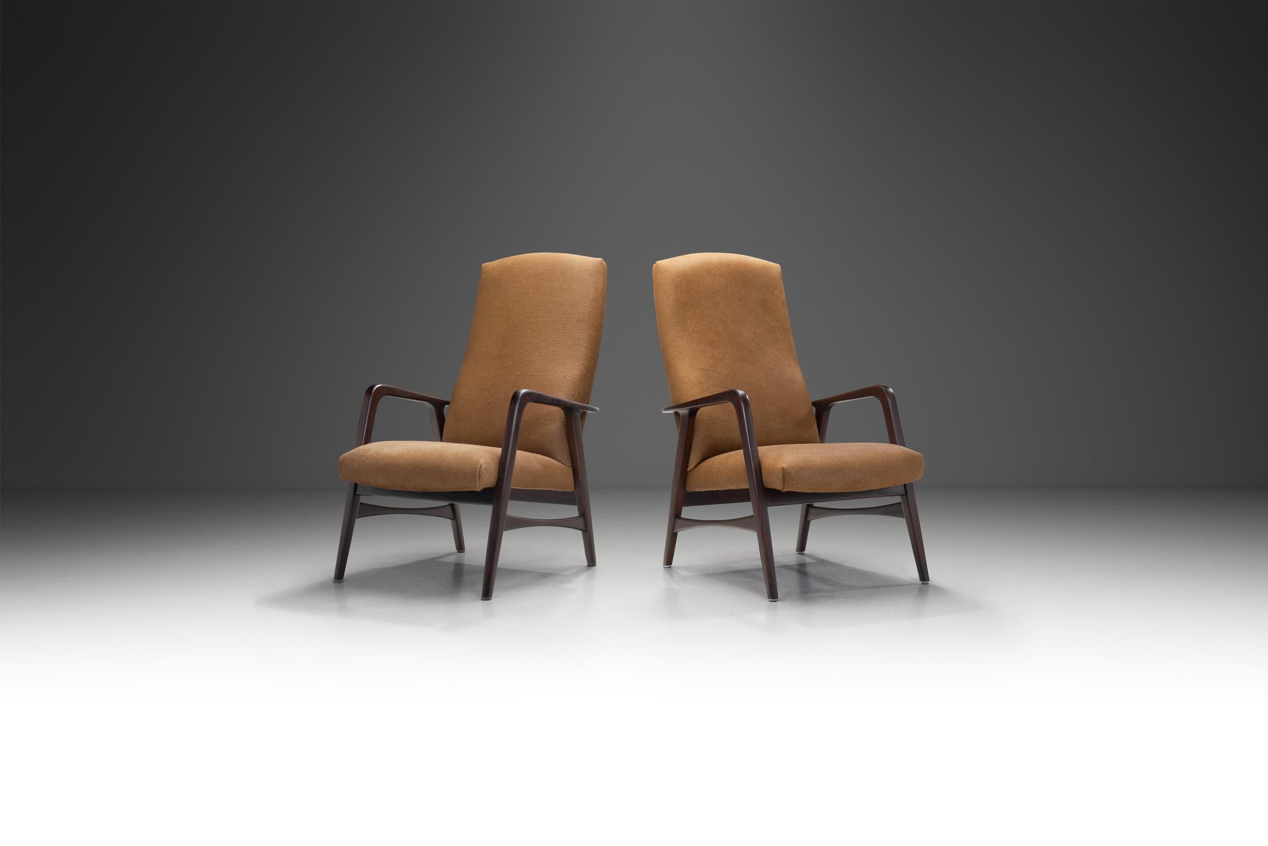 This pair of Danish cabinetmaker chairs, is a great example of the Danish mid-century modern aesthetic. With their architectural, dark stained wood frames and bodies upholstered in brown cow hide, these lounge chairs are stylish, and in possession