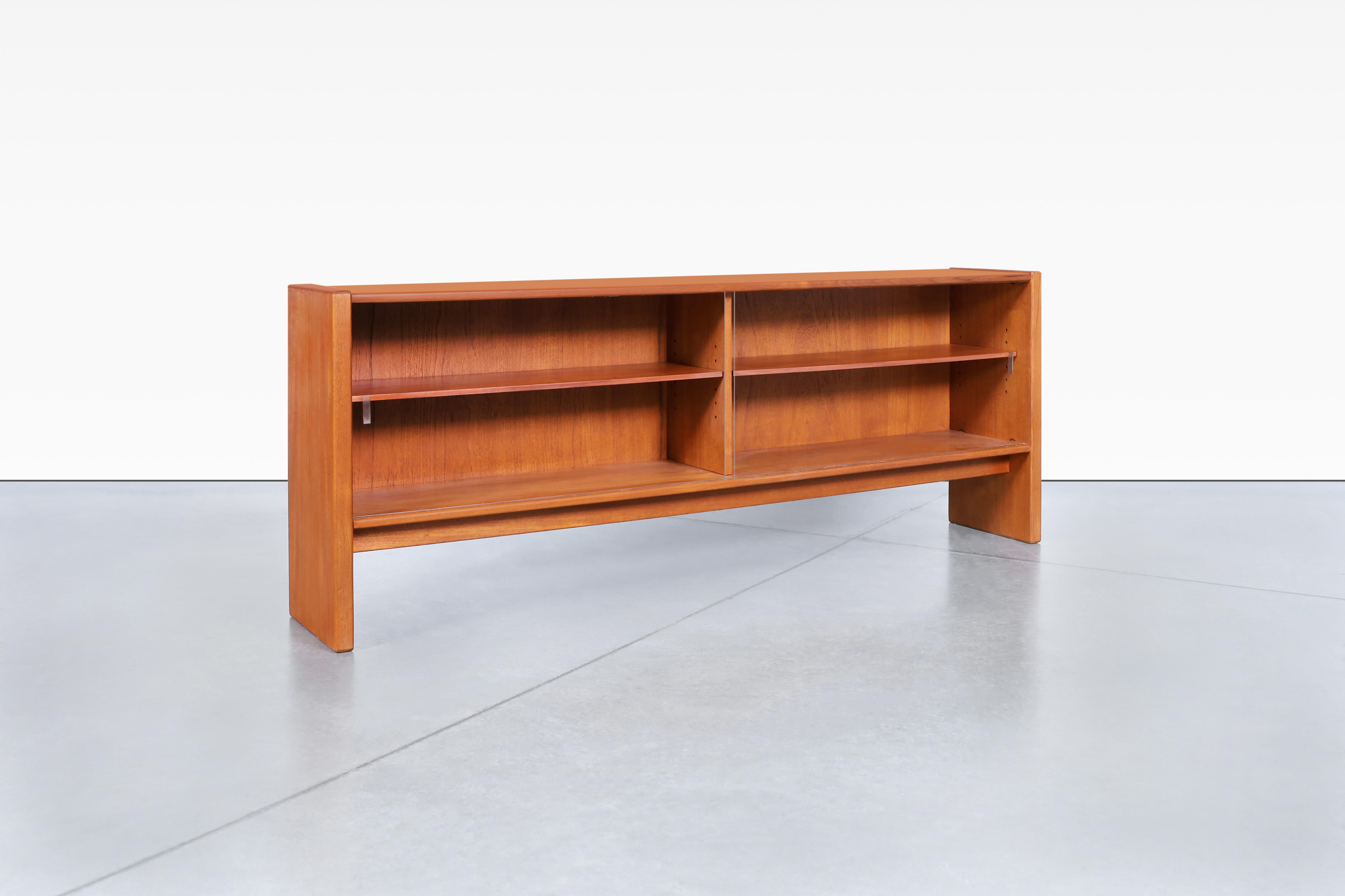 This beautiful Danish low-profile teak bookcase, crafted by Skovby Møbelfabrik in Denmark in the 1960s, boasts a minimalist yet highly functional design. The stunning teak wood is accentuated by the mesmerizing grains, creating a truly captivating