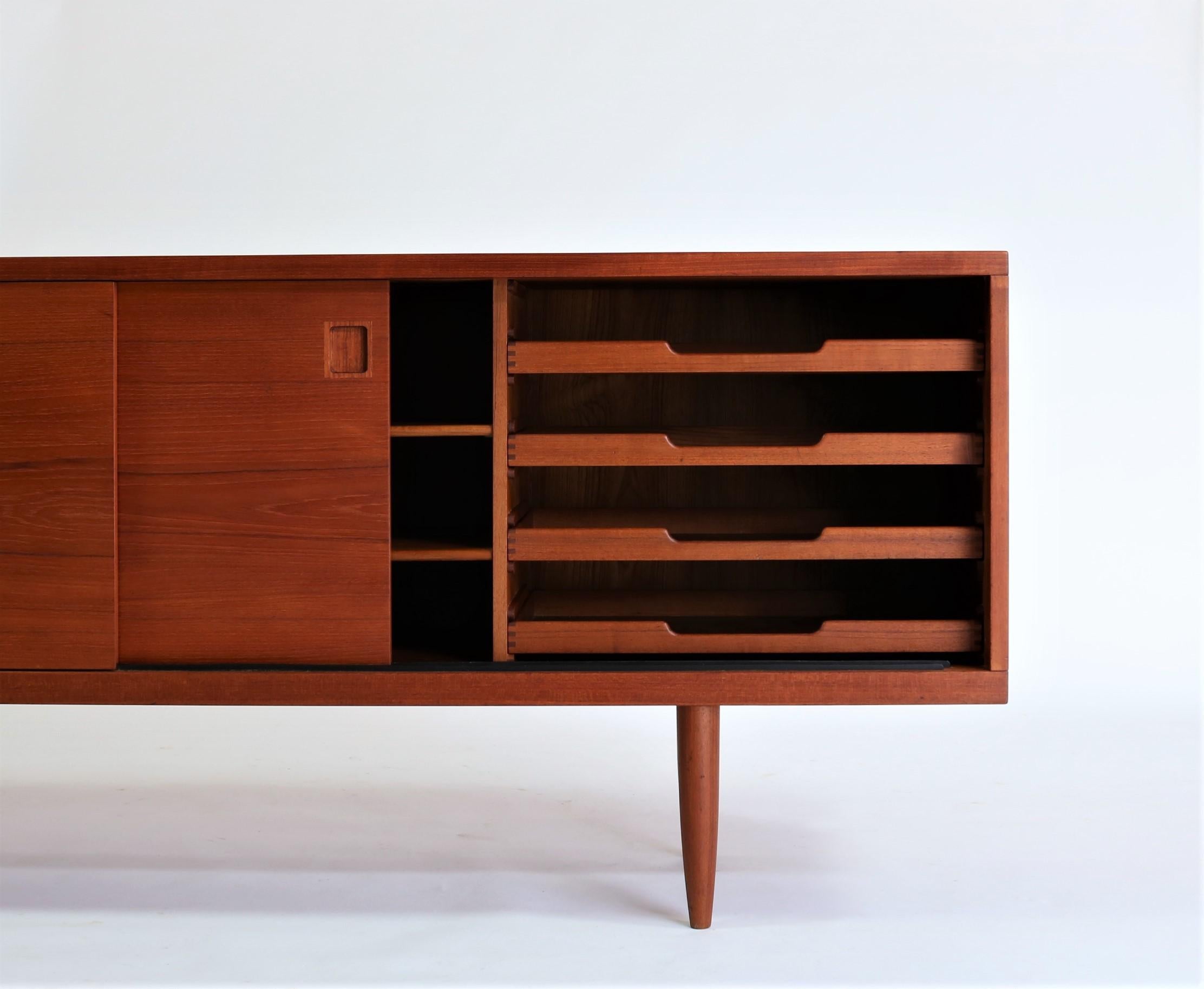 Stunning 1960s furniture design by Niels Otto Moller. Low sideboard/credenza in simplistic design with nice details like the beautifully carved edges on the top and the finger joints on the solid teak drawers. The interior is fully made out of teak