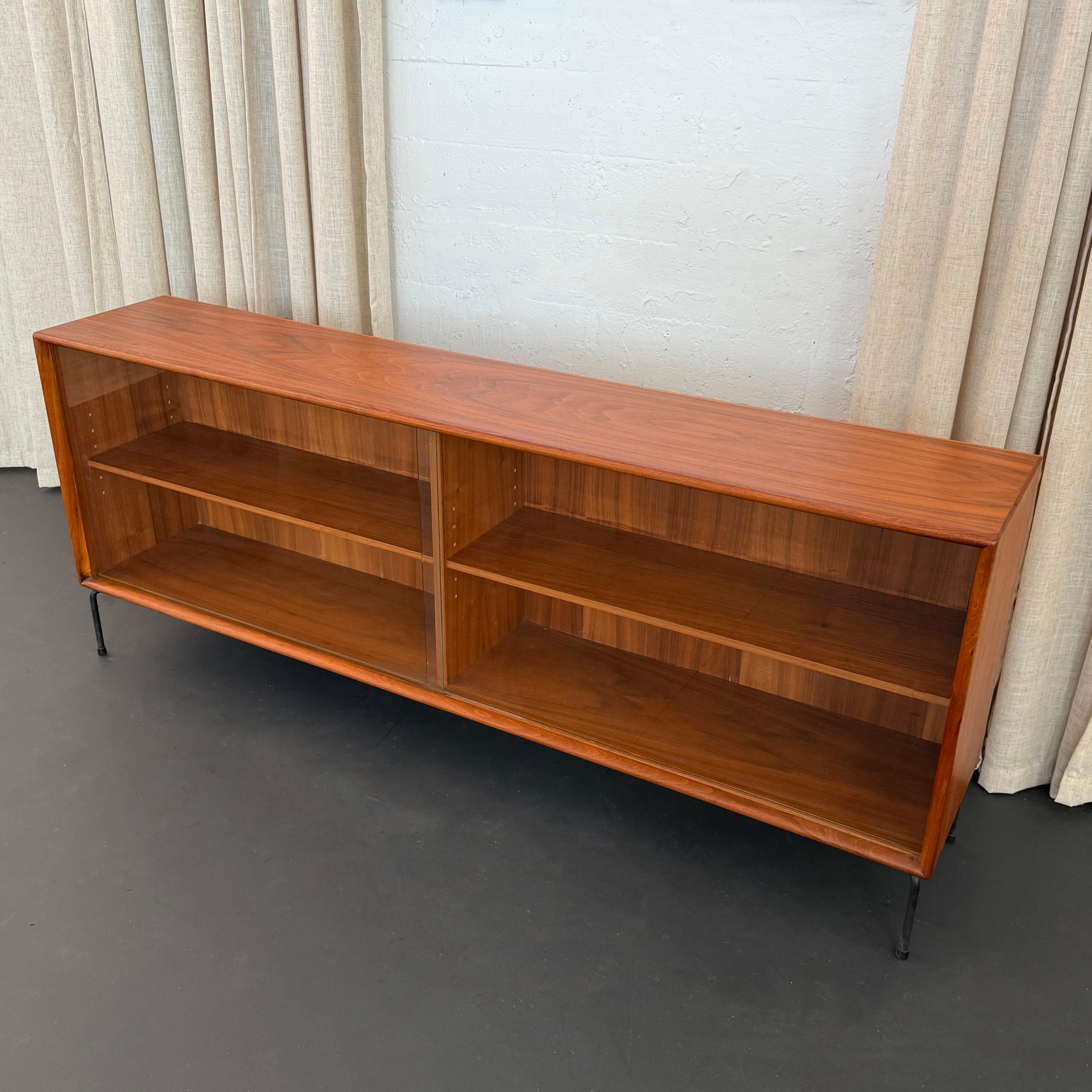 This teak glass front credenza was designed by Axel Christensen for Aco Møbler, Denmark circa 1960s. The credenza is solid teak with sculpted edge banding which is a signature of Danish design. The 20