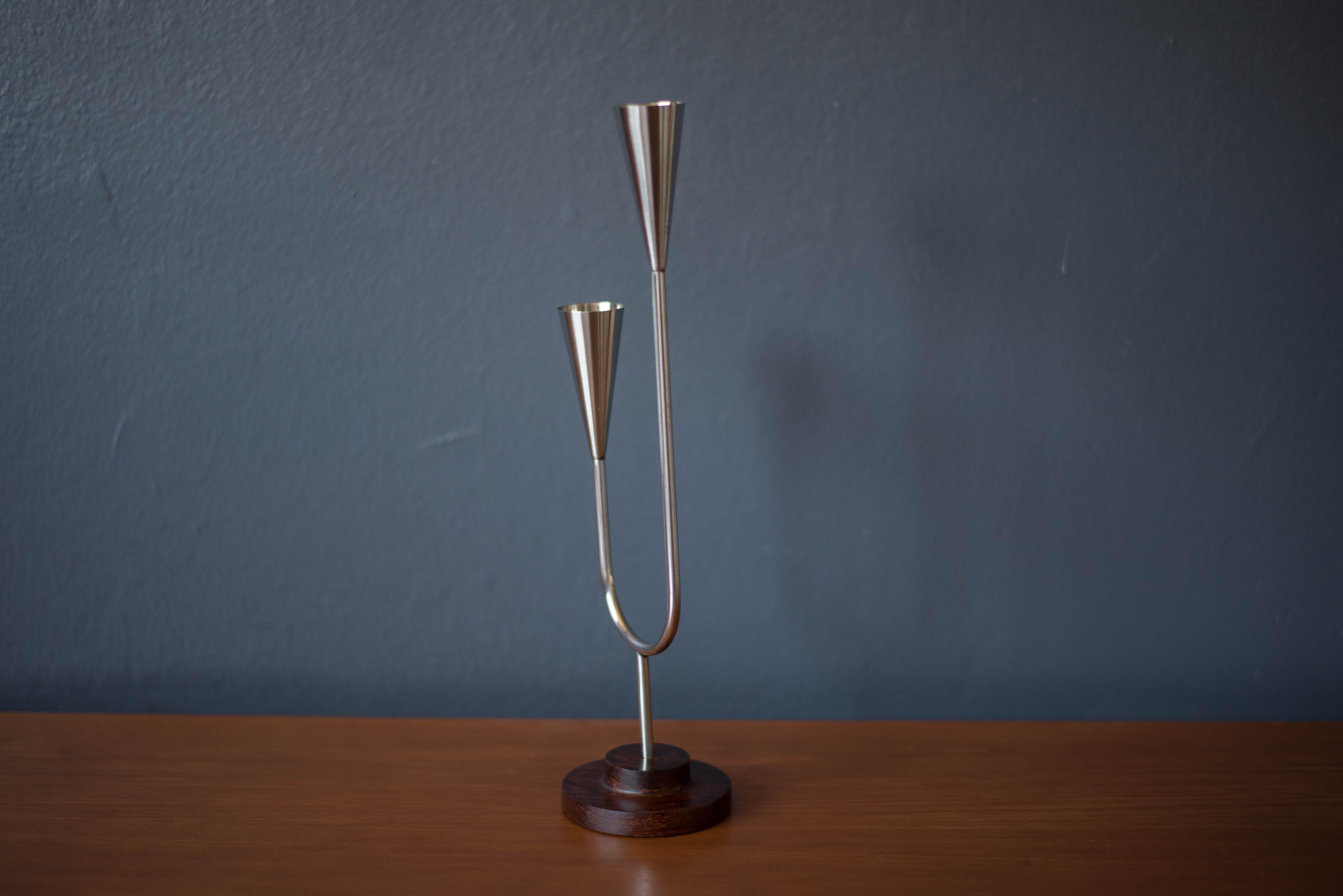 Mid-Century Modern candle holder manufactured by DFK Lundtofte, Denmark, c. 1960's. Features a solid rosewood pedestal base and a polished stainless steel stem that fits two taper candles.
