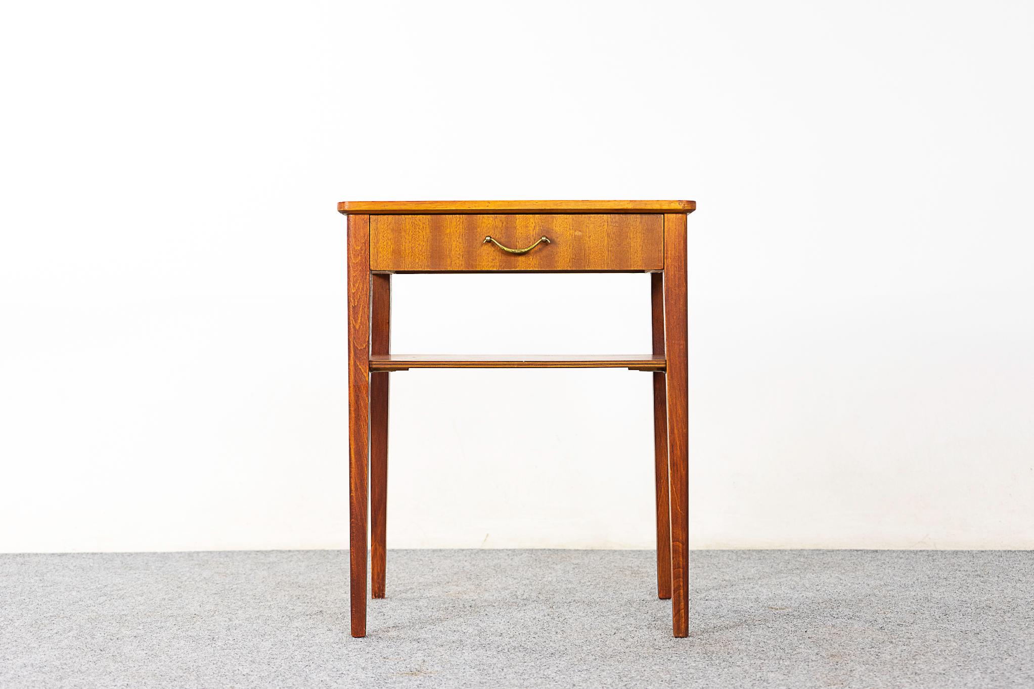 Mahogany mid-century bedside table, circa 1960's. Beautifully veneered case and drawer face, slender tapered legs. Handy shelf and a dovetailed drawer with elegant metal handle. 

Please inquire for remote and international shipping rates.