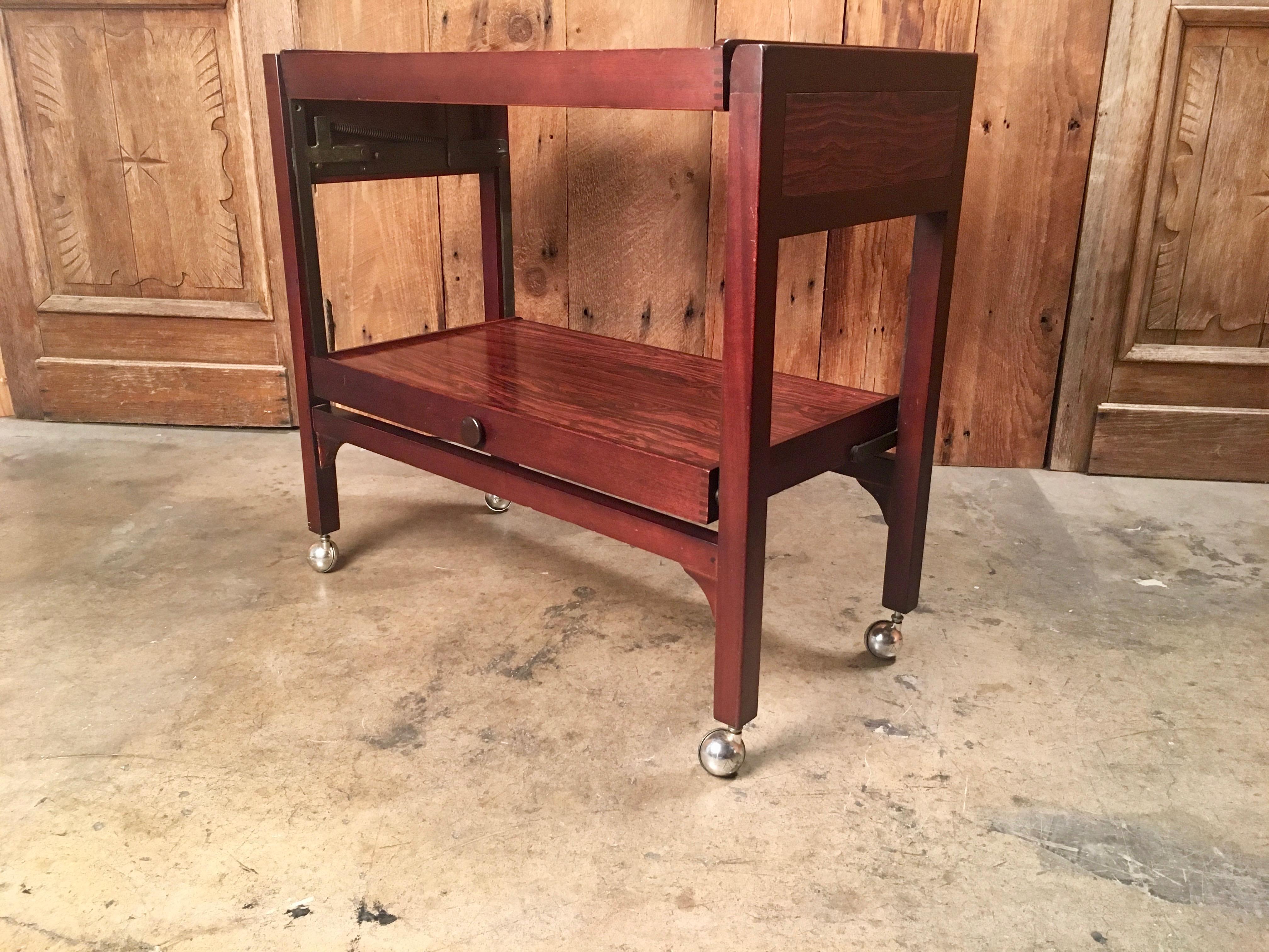 Rosewood bar cart that converts into a serving table with box joint corners.