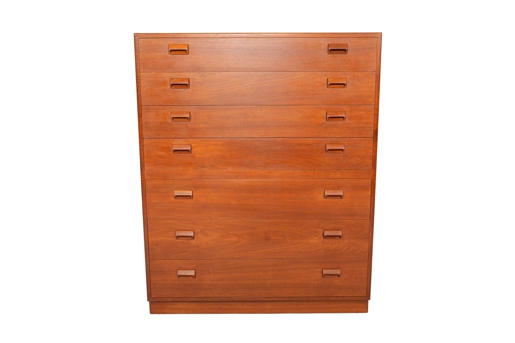 This beautifully crafted Danish teak highboy dresser was designed by Børge Mogensen for Søborg Møbelfabrik in 1951. The case is crafted in teak and stands on a teak plinth base. Each drawer is adorned with the designer's signature handle. Three