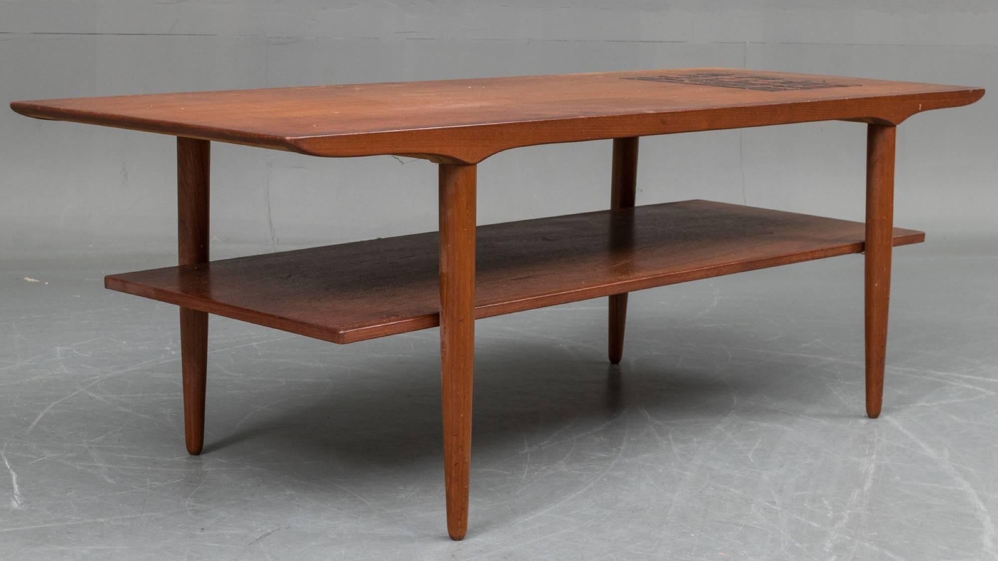 Teak wood and tile coffee table with second shelf. Danish furniture manufacturer, 1960s.