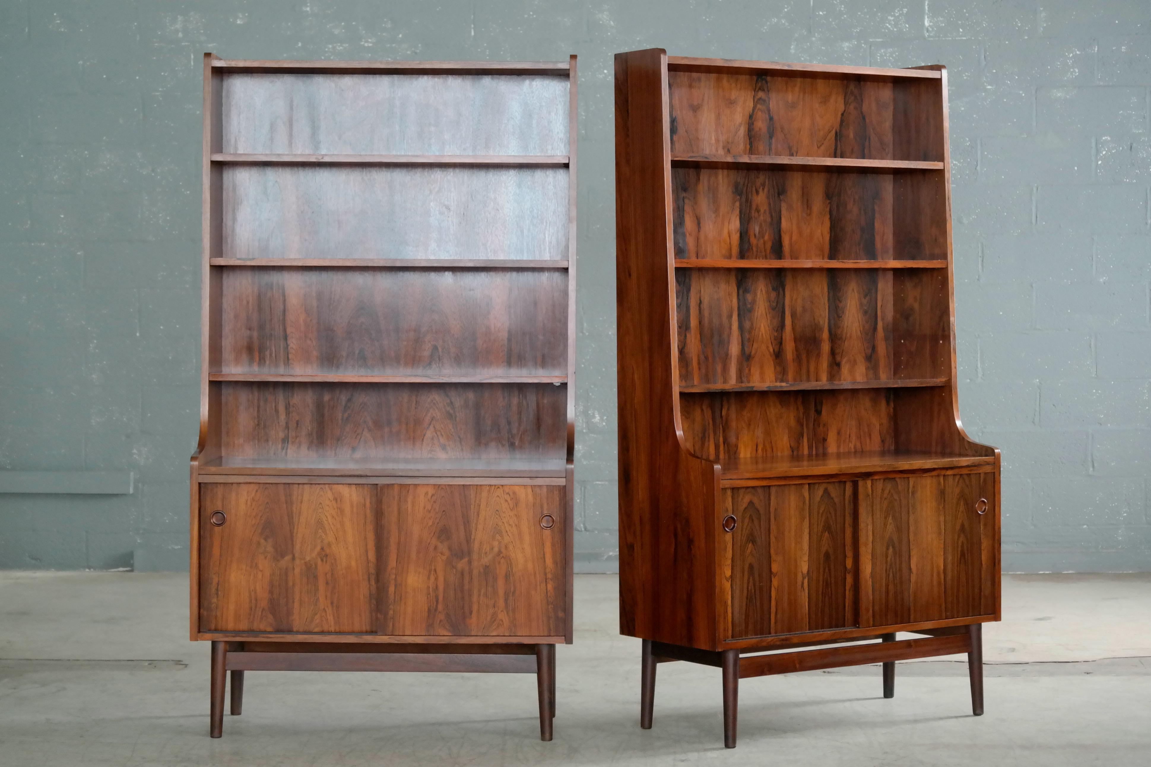Beautiful and elegant pair of bookcases in bookmatched rosewood with beautiful deep and dark rosewood color and rich grain. Designed by Johannes Sorth for Bornholm's Mobler also known as Nexoe Teak. Very versatile with adjustable shelves and two