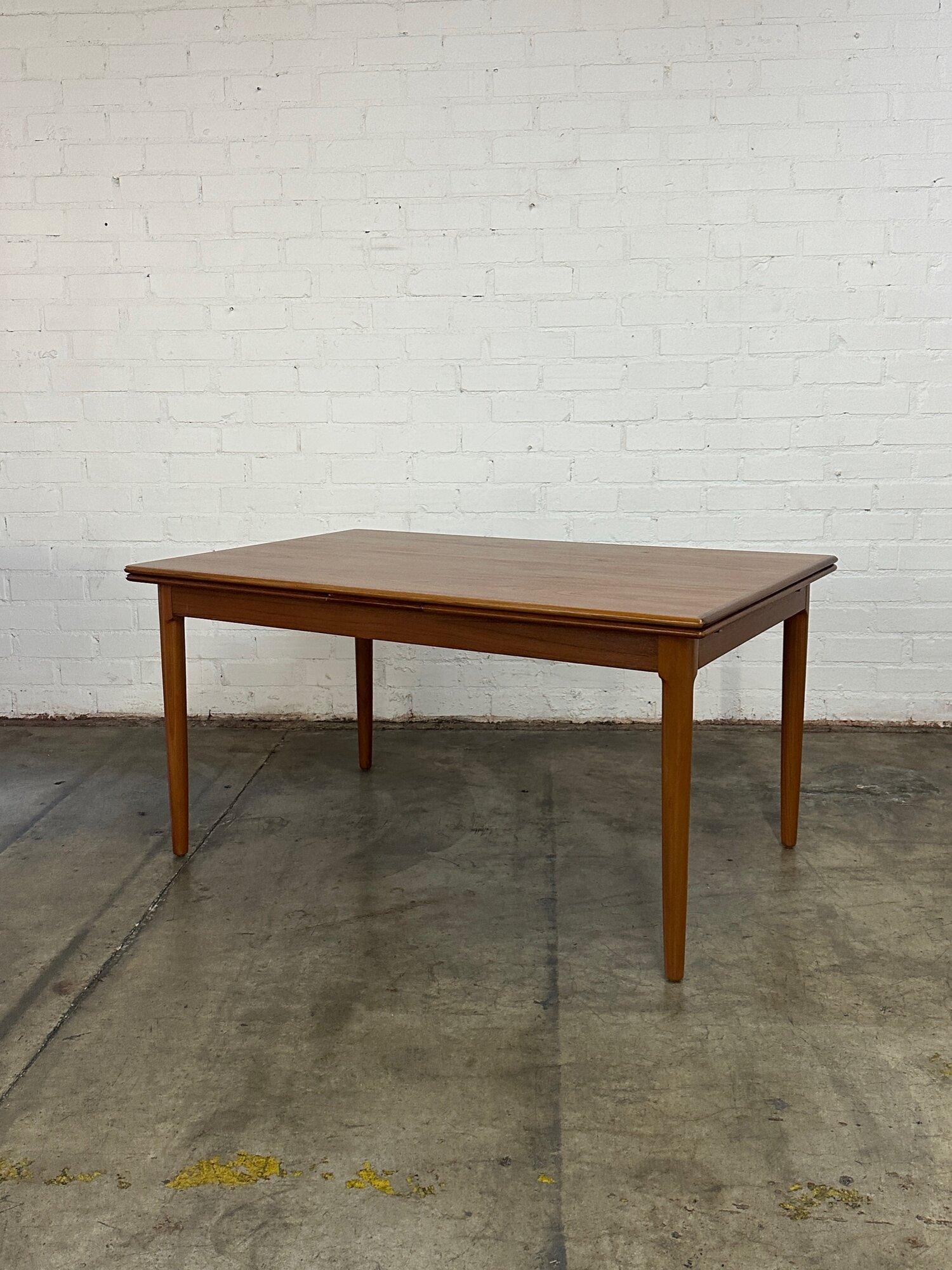 W105 W57 D38 H29 KC24

Minimal teak dining table with extensions that slide underneath surface. Table is strucutrually sound, sturdy and fully functional. Item has been fully restored and shows very well with no major areas of wear visible. 

