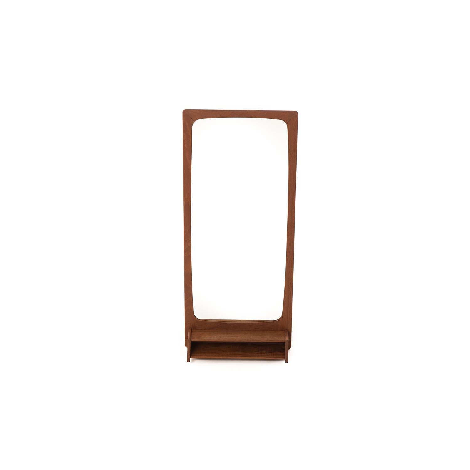 The built in shelf makes this Danish modern teak mirror Stand out from the rest. Perfect spot for your keys, lipstick or business cards. A great piece for coming and going areas of your home.