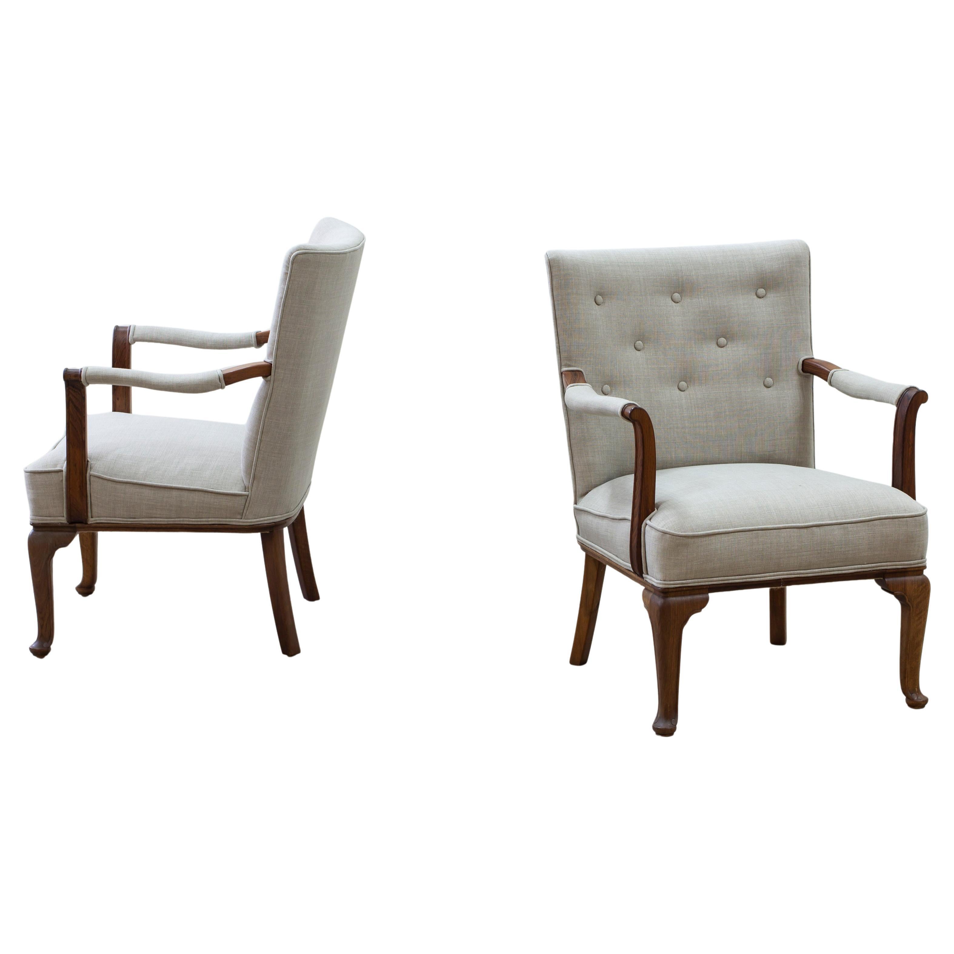 Arm chairs med in Denmark by Lysberg & Hansen. A traditional combination of neoclassical and Danish modern made during the 1930-40s. Made from walnut with new linen upholstery. Very good vintage condition with light age related wear. Upholstery is