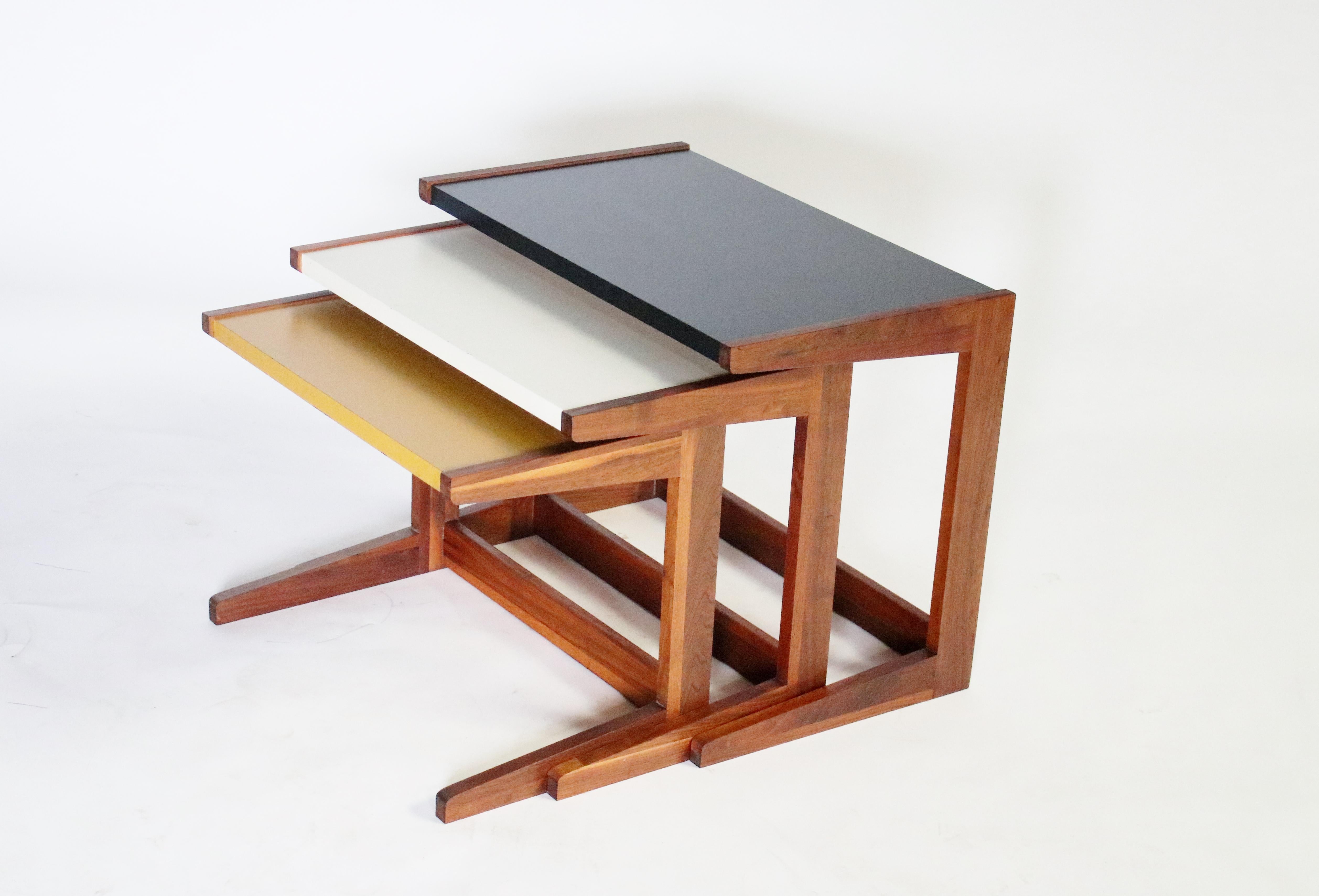 Set moderno danese di tre tavolini a nido con piani originali in legno dipinto, tra cui nero, bianco sporco e senape. Struttura a C robusta e ben realizzata, realizzata in teak e noce con incastri a incastro.
Le tabelle misurano
Il più grande: