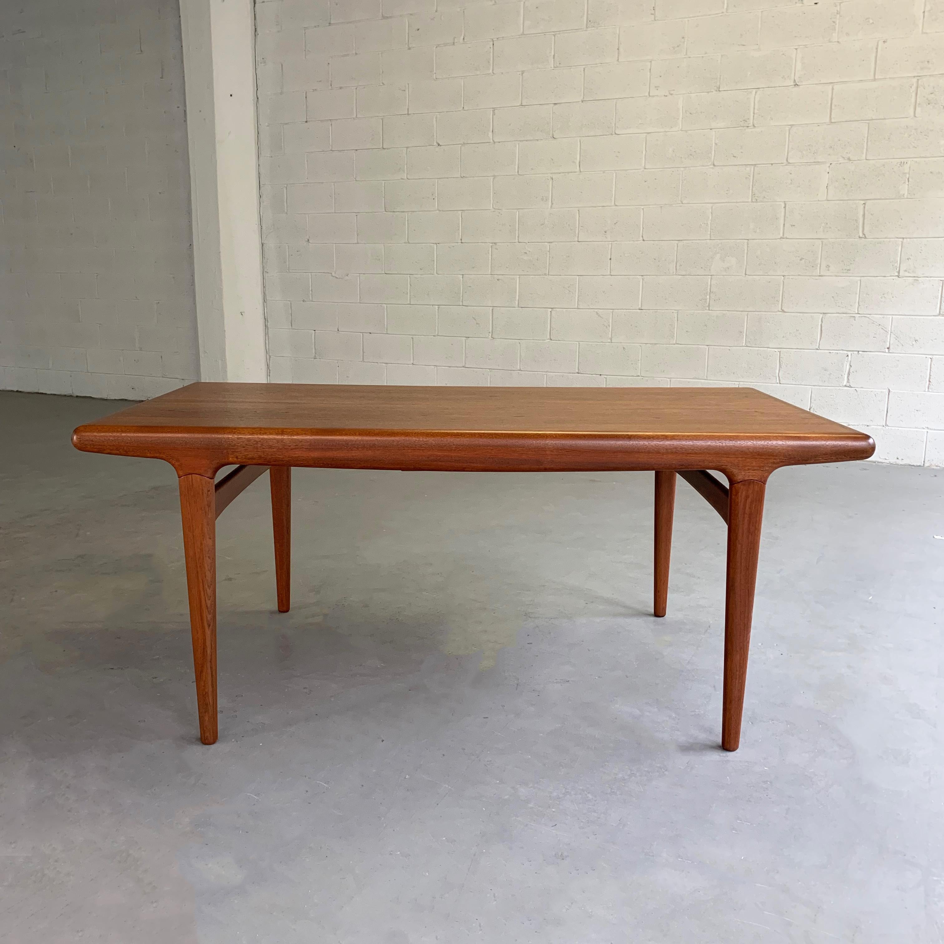 Danish modern, teak, dining table by Niels O. Moller for J.L. Møllers Møbelfabrik features beautiful organic lines and tapered legs. Each end of the table opens to reveal a built-in storage drawer that houses 1 leaf each, extending the table to 116