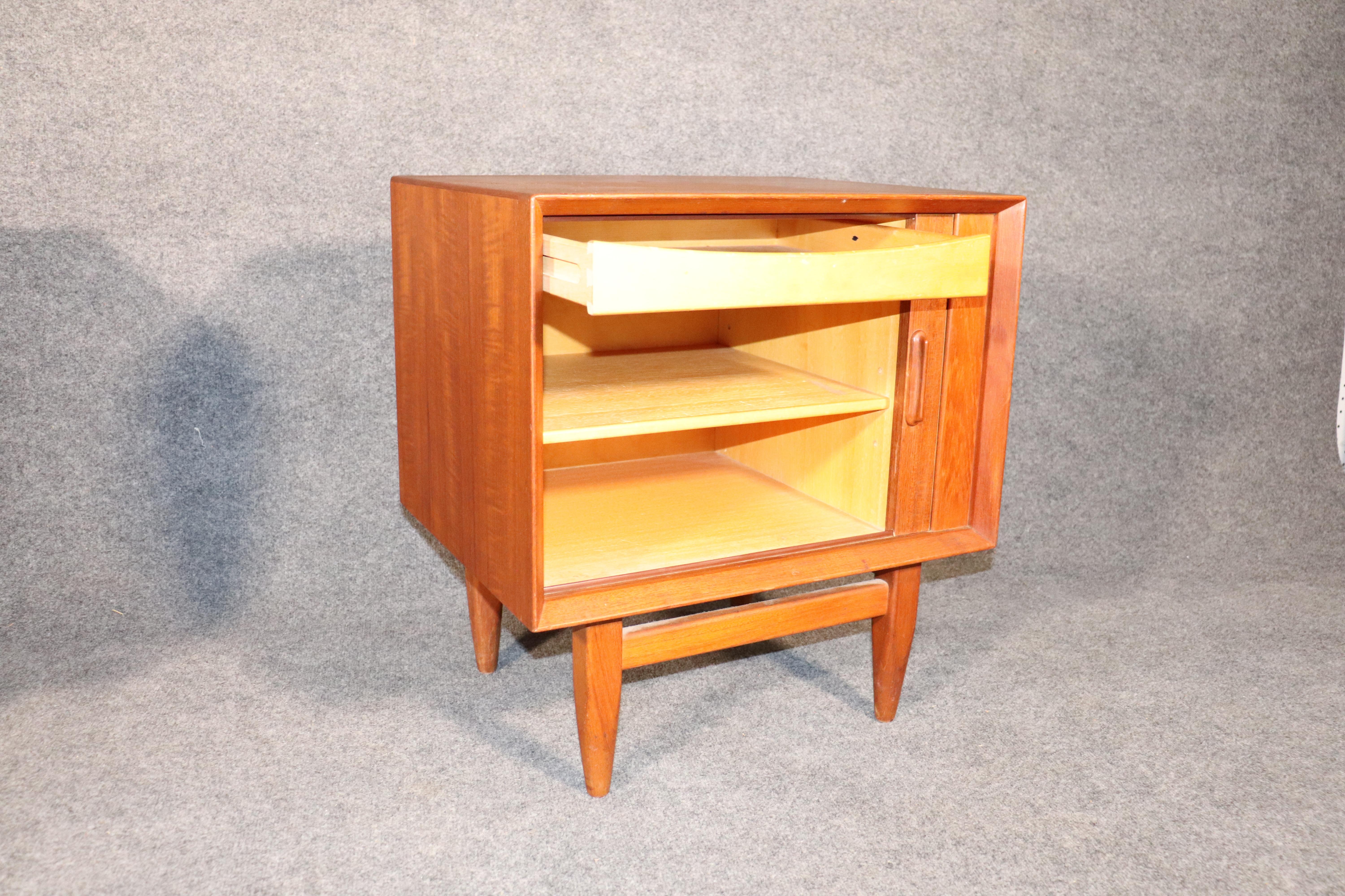 Pair of Mid-Century Modern end tables with tambour doors that recede behind the cabinet. Simple Danish design with storage for living room or bedroom.
Please confirm location.