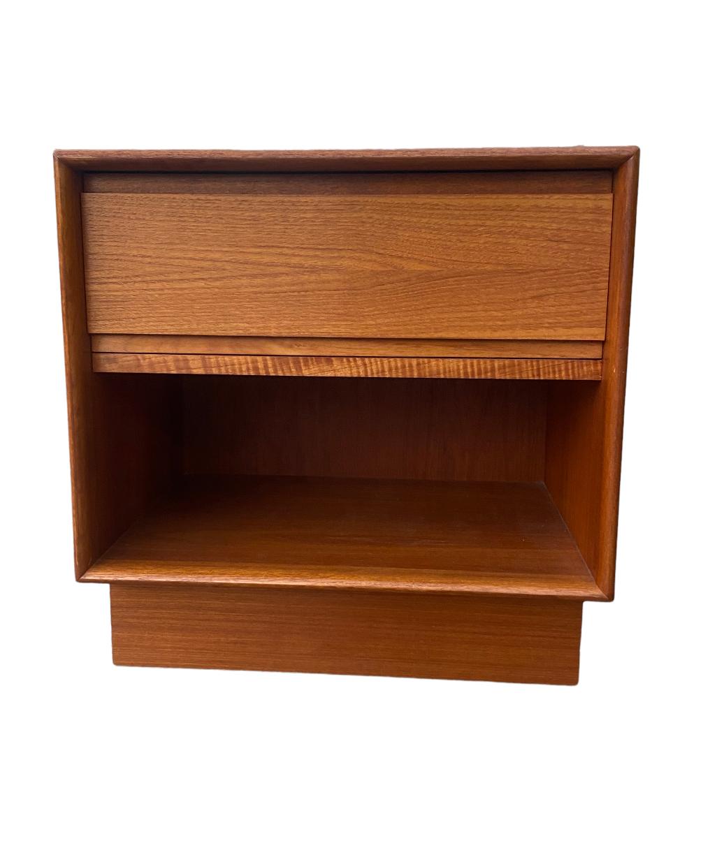Beautiful pair of Danish modern nightstands. Executed in vibrant teak. Simple, functional design, with spacious drawer and cabinet upon plinth base. In good vintage condition. Surfaces have been cleaned and oiled. Drawers function smoothly.