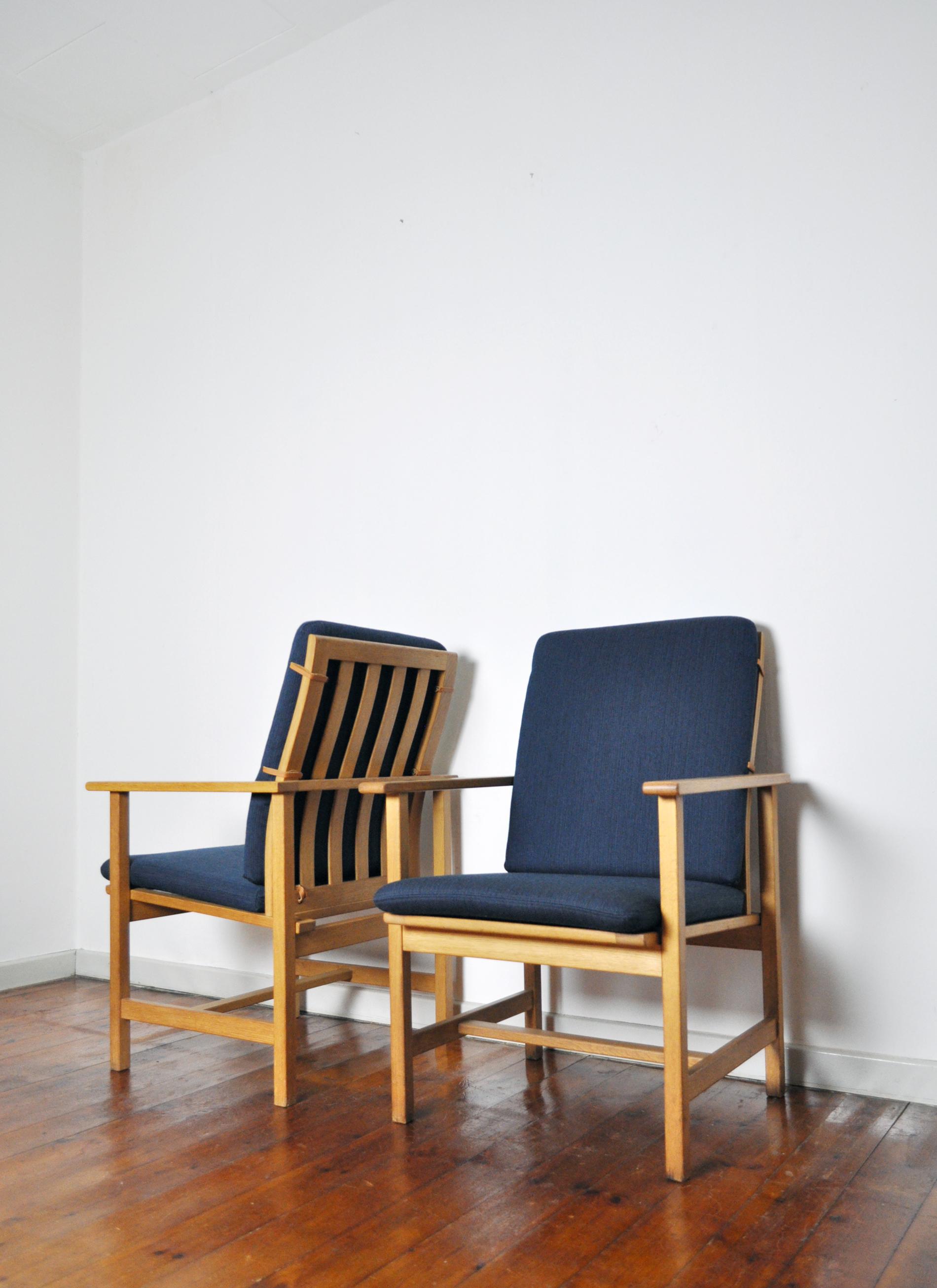 Sharp clean minimalistic design in these Classic oak lounge chairs model 2257 designed by Børge Mogensen for Fredericia Stolefabrik.

New navy blue wool upholstery with leather straps. Oak frame gently refurnished.
Labelled by