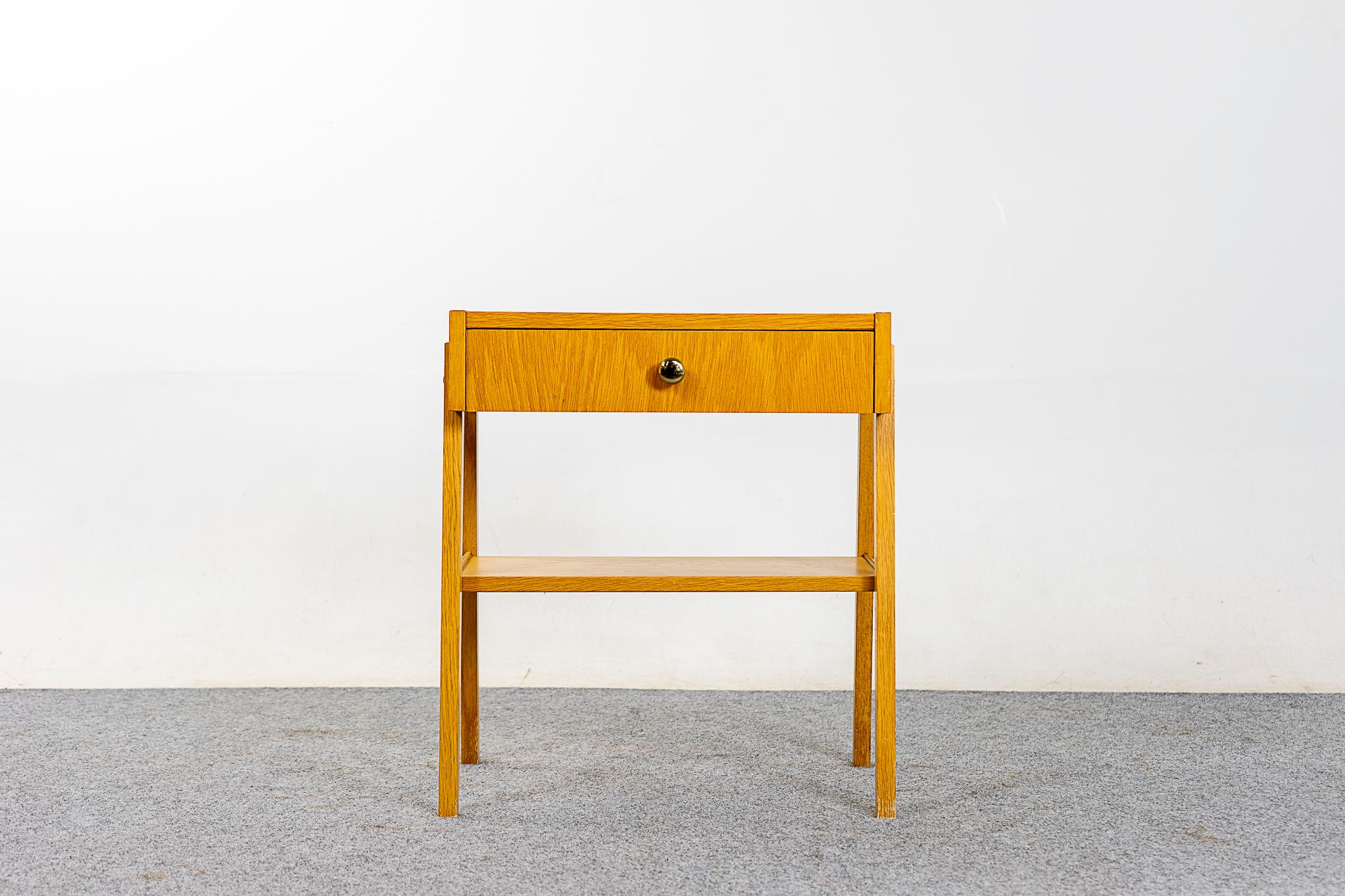 Oak Danish midcentury bedside table, circa 1960s. Dovetailed drawer offer storage for small items, lower shelf is perfect for your favorite book! Beautifully veneered case rests on slender splayed legs.

Unrestored item, some minor marks consistent