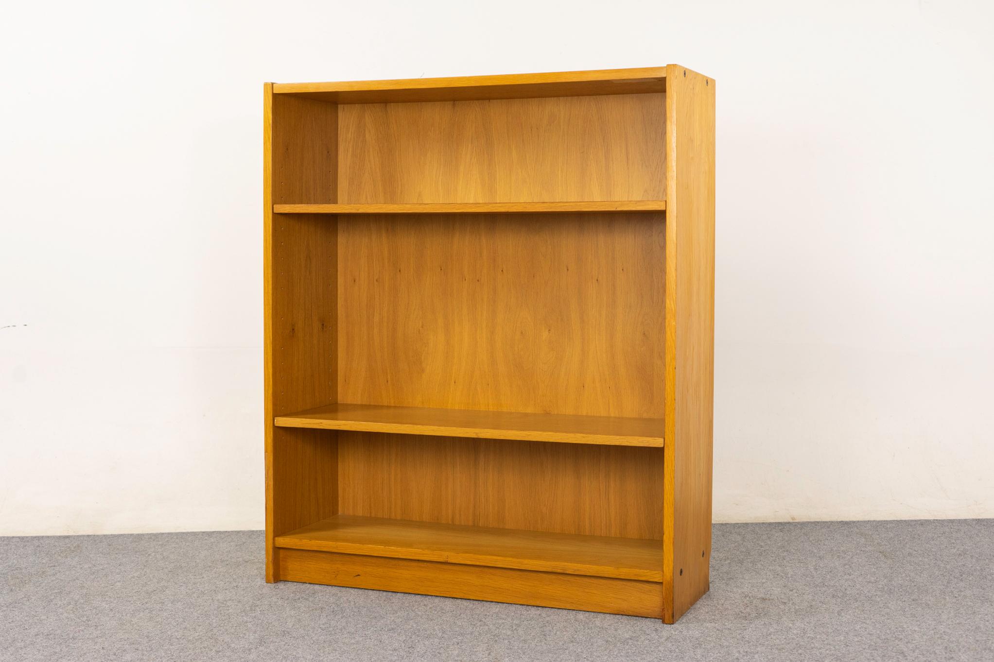 Libreria danese in Oak, anni '70 circa. Libreria elegante e moderna con impiallacciatura in tinta con il libro, base a zoccolo e due ripiani regolabili. Venduto così com'è con lievi segni di usura.


