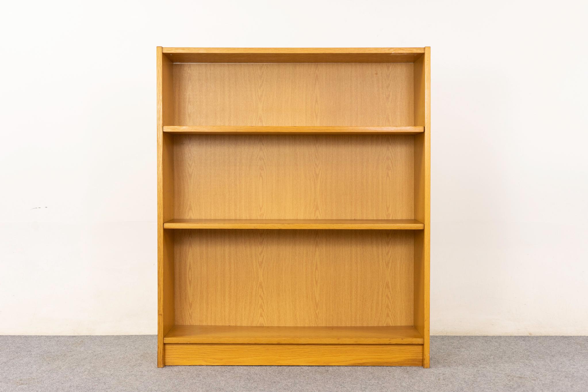 Libreria danese in Oak, anni '70 circa. Libreria elegante e moderna con impiallacciatura in tinta con il libro, base a zoccolo e due ripiani regolabili. Venduto così com'è con lievi segni di usura.

