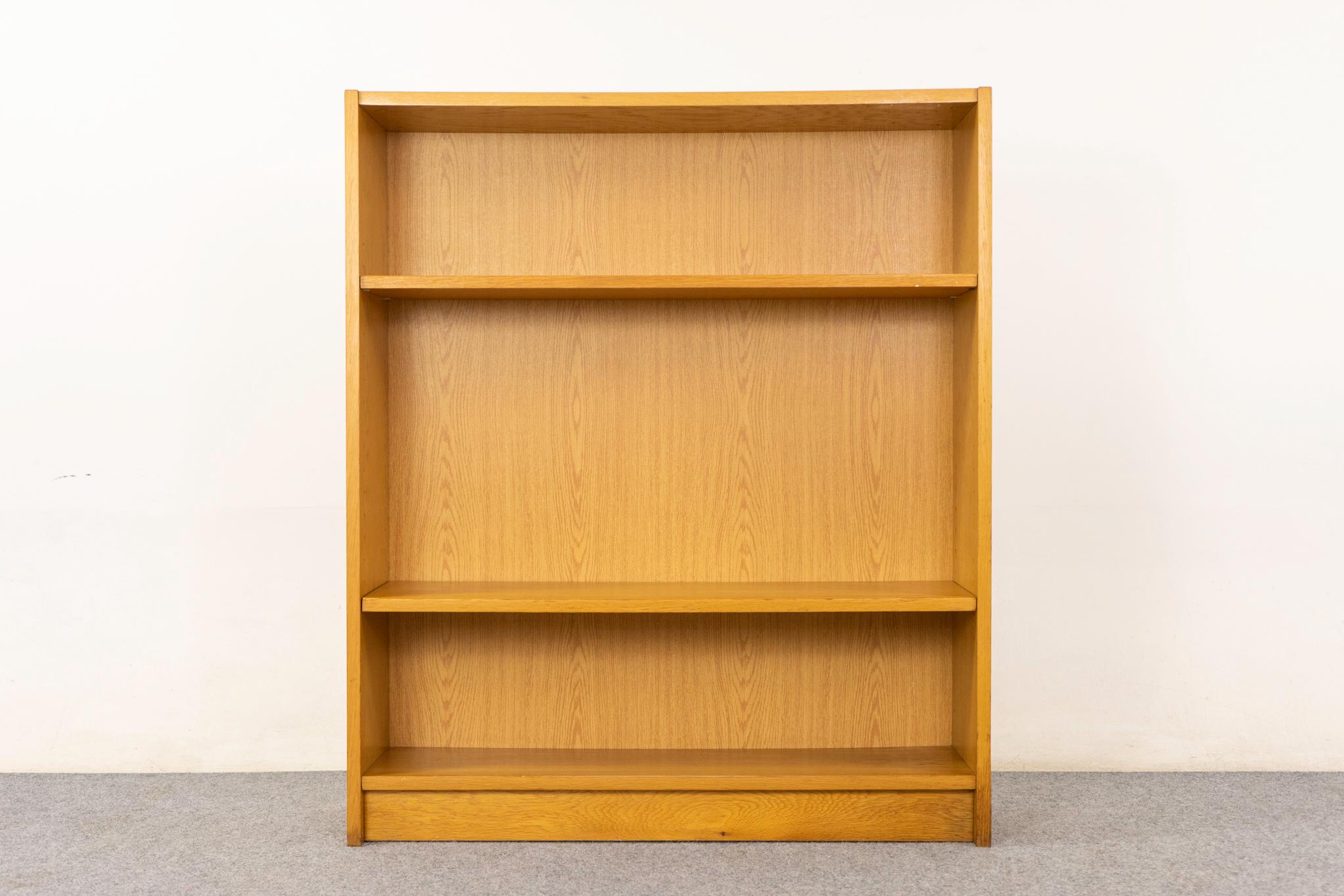 Libreria danese in Oak, circa anni '70. Libreria elegante e moderna con impiallacciatura in tinta con il libro, base a zoccolo e due ripiani regolabili. Venduto così com'è con lievi segni di usura.

