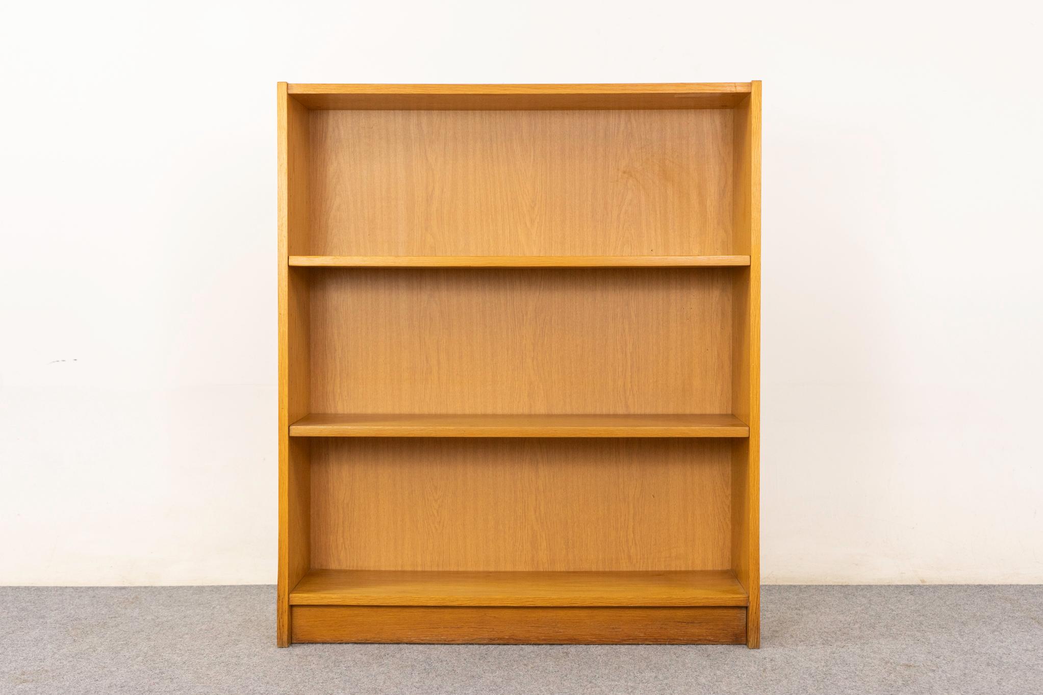 Libreria danese in Oak, circa anni '70. Libreria elegante e moderna con impiallacciatura in tinta con il libro, base a zoccolo e due ripiani regolabili. Venduto così com'è con lievi segni di usura.

