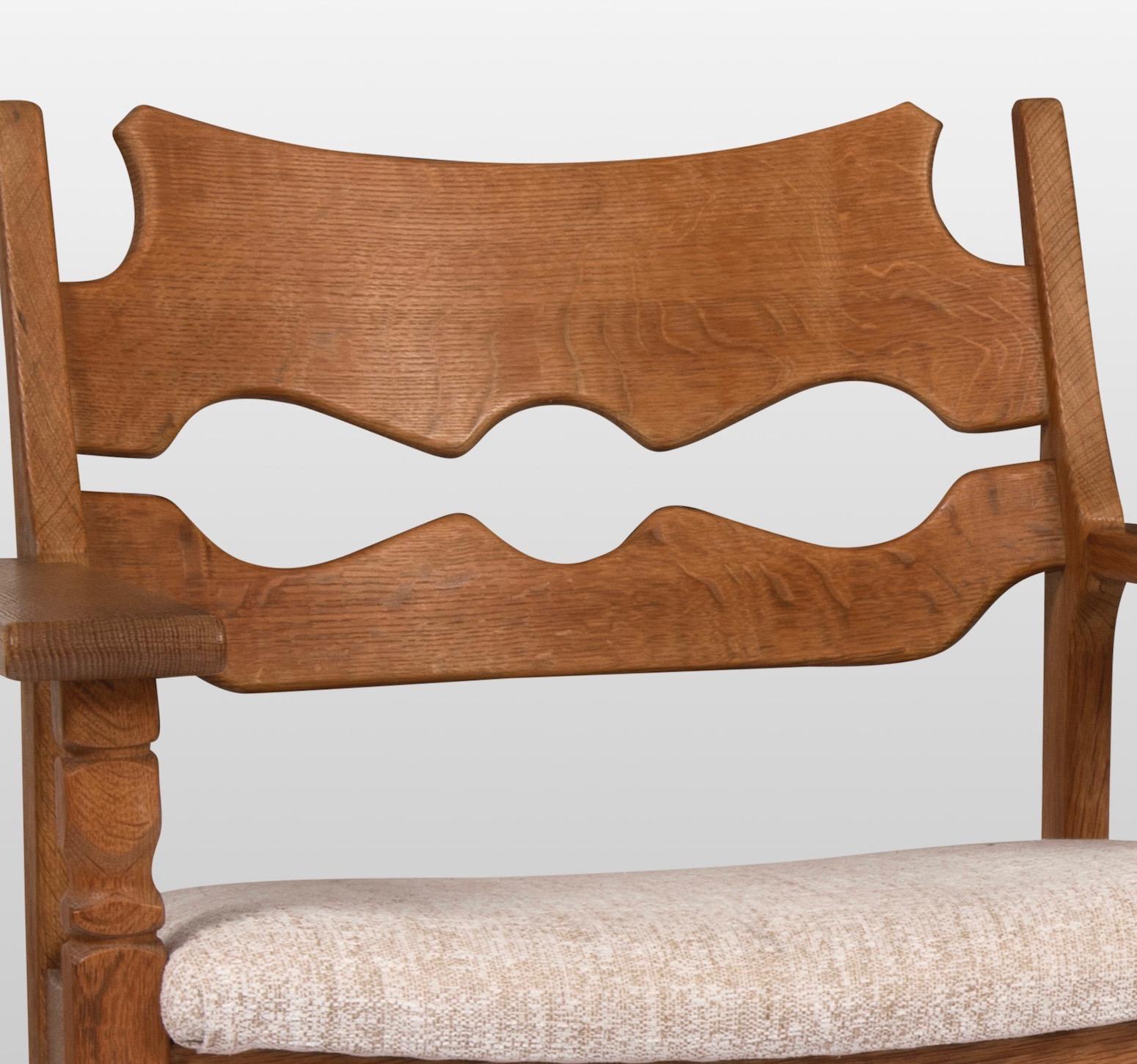 A pair of razorback lounge chairs by Danish designer Henning Kjaernulf. This is his iconic design. Made of oak and reuphostered in toile chiné. Manufactured by EG Kvalitetsmøbel.