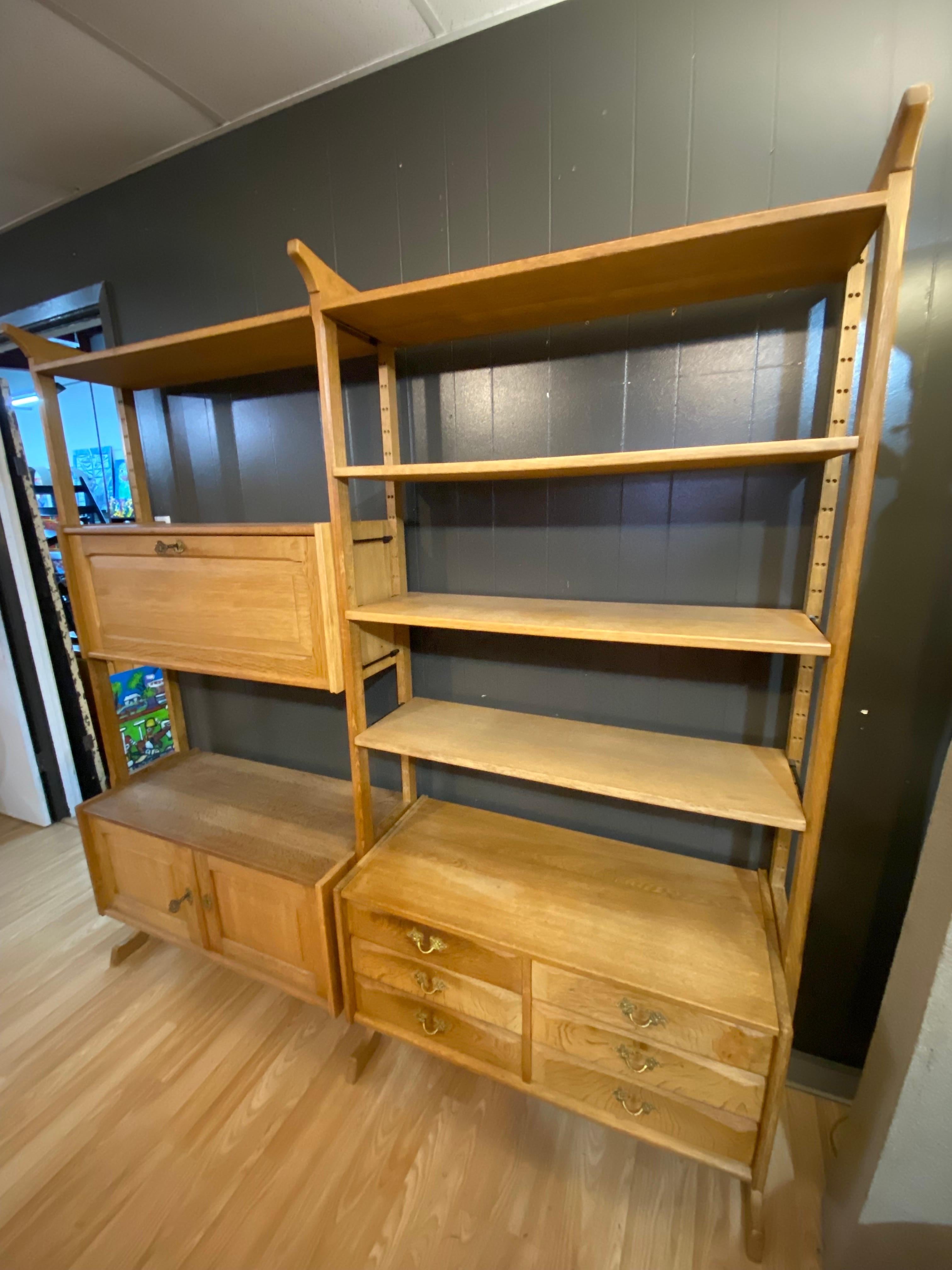 Beautifully detailed Danish modern brutalist solid oak shelving in the manner of Henning Kjærnulf features hand-crafted details and plenty of storage. On the left side there is a top compartment has two shelves and one open compartment and the