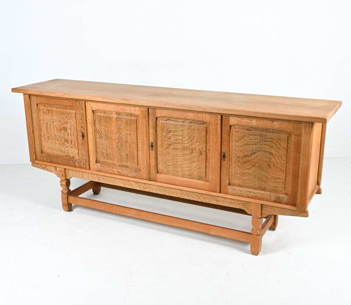 Make a statement with this stunning sideboard attributed to Henning Kjærnulf. Crafted from quarter-sawn white oak, this piece features subtle sculpted details throughout - including chamfered molding on the door panels and Kjærnulf's signature