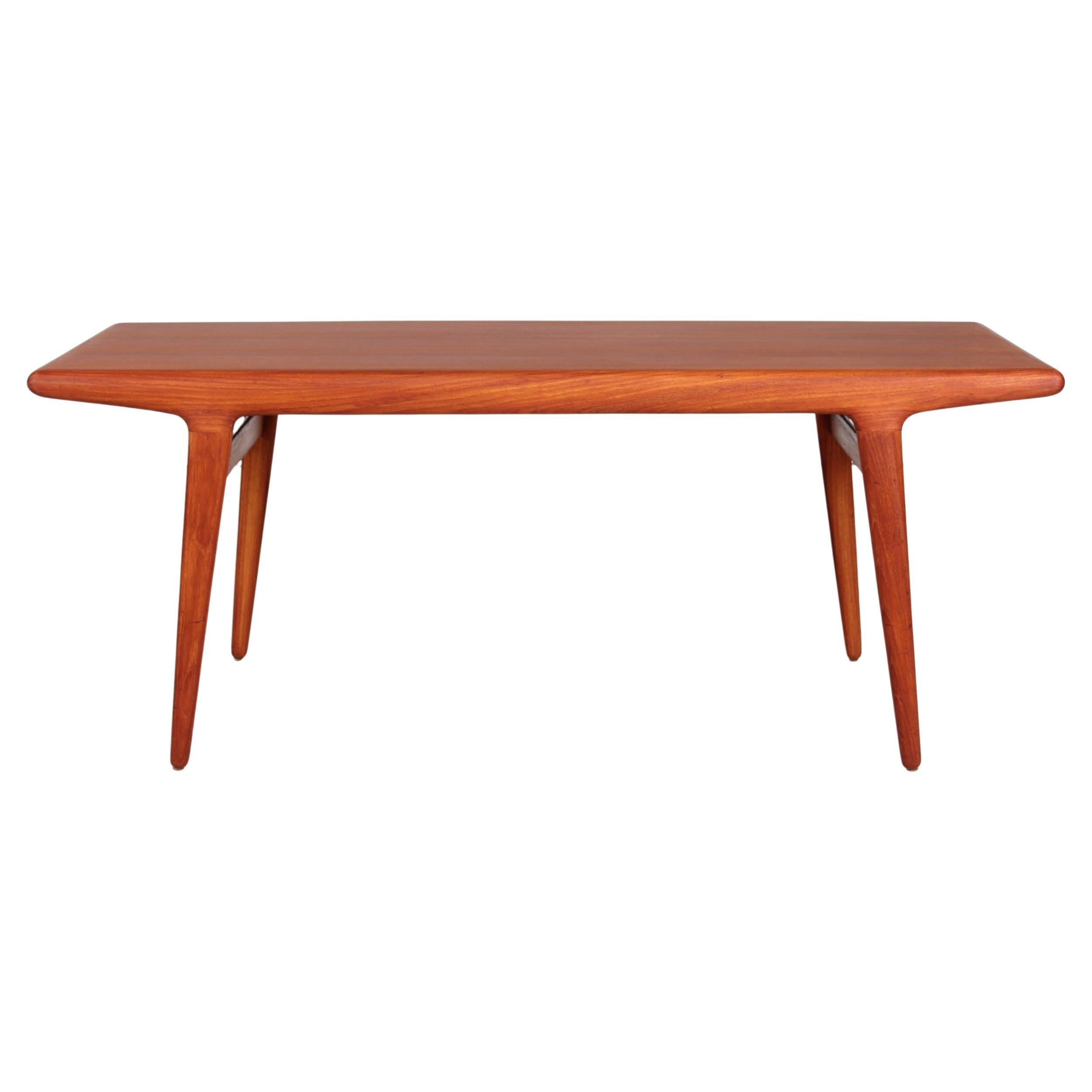 Oblong coffee table with slightly slanted or angled legs with a slender teak strip between.
It's in the style of N. O. Møller, Johannes Andersen and Kai Kristiansen made by  a Danish cabinetmaker in the 1960s.


Nice vintage condition without any