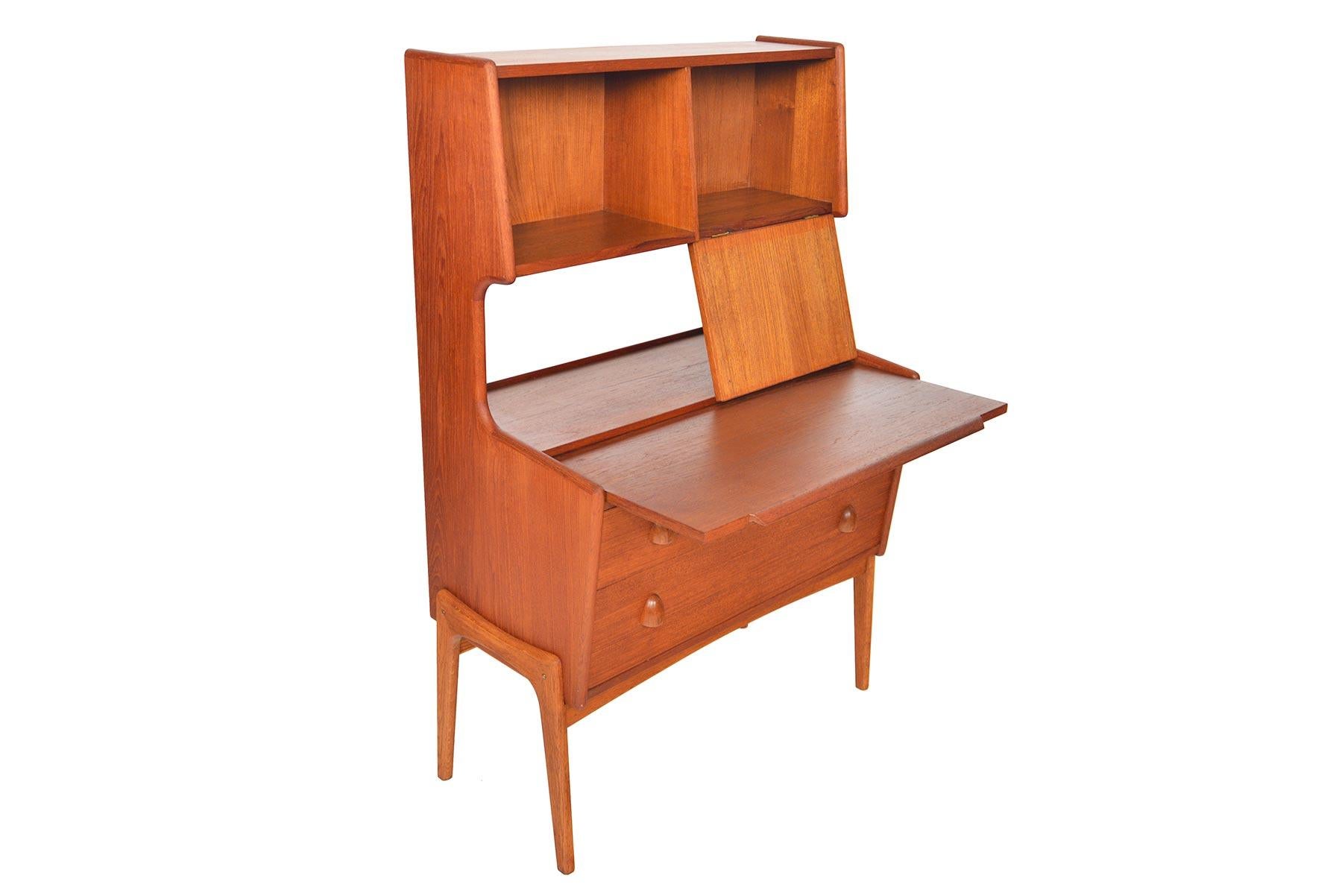 This Danish modern secretary desk offers a light and airy profile. This two-tier design features two upper compartments with a drop down door. The desk surface extends forward to provide a work space. Two lower drawers provide additional storage.