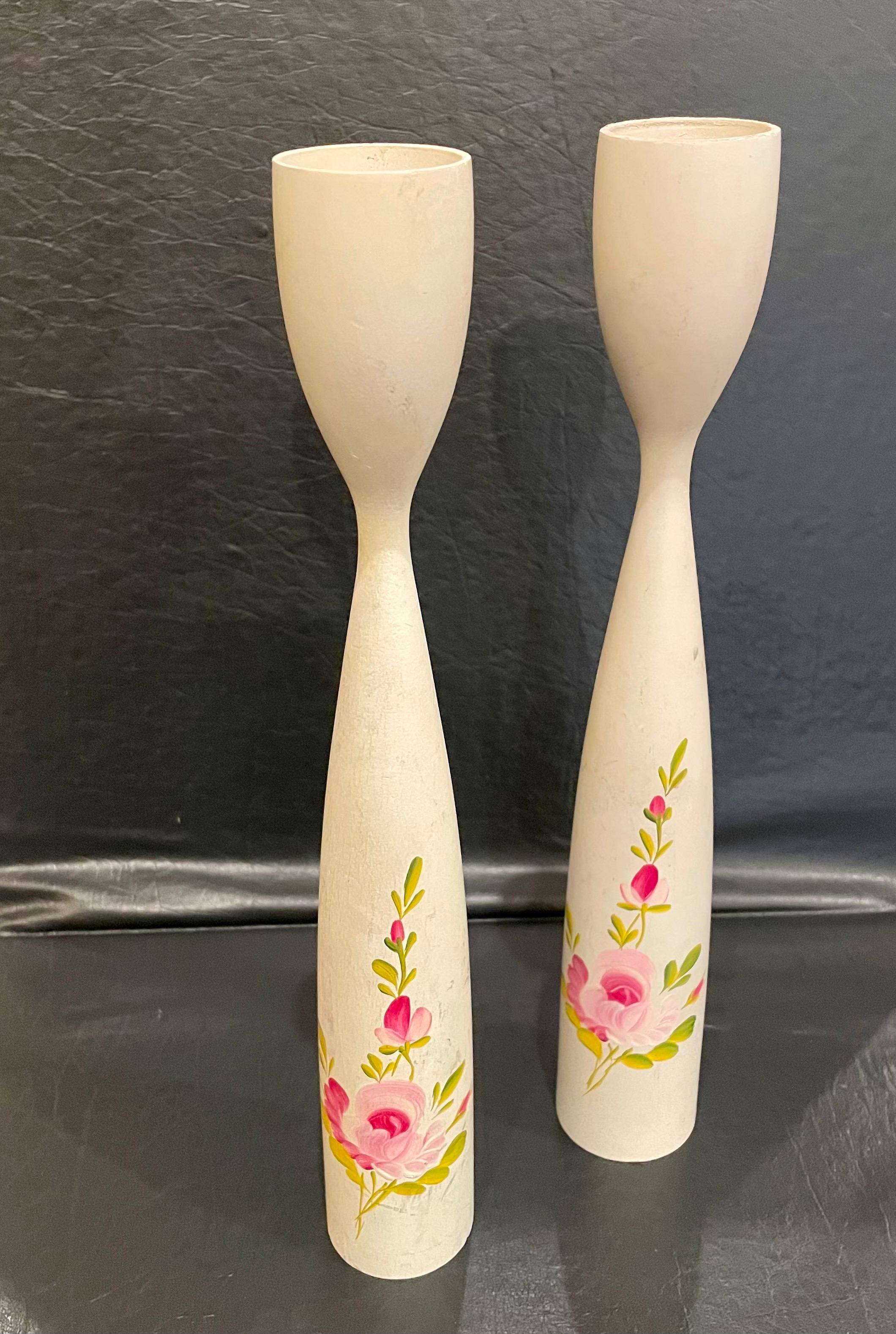 An incredible pair of rare solid turned wood candlesticks with a brass edge on the top and handpainted decorative flowers, circa 1950's.

 