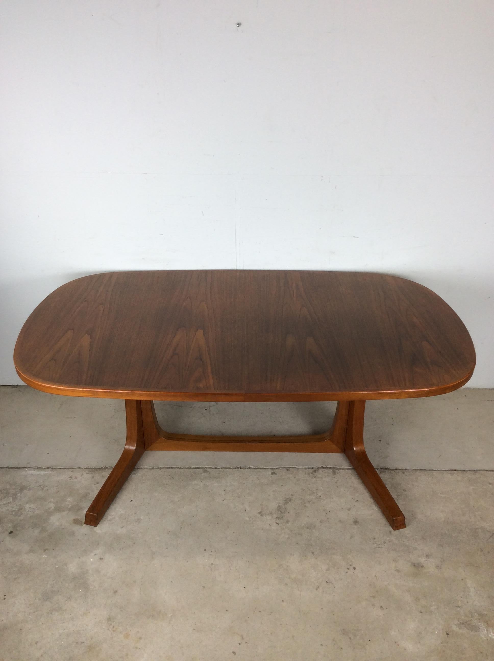 This Danish modern dining table features hardwood construction, teak veneer with original finish, oval top with two removable leafs for additional space, and pedestal base. 

Max Width with Leaves in 13.5 (2 leaves at 19.25w each)  Matching set of