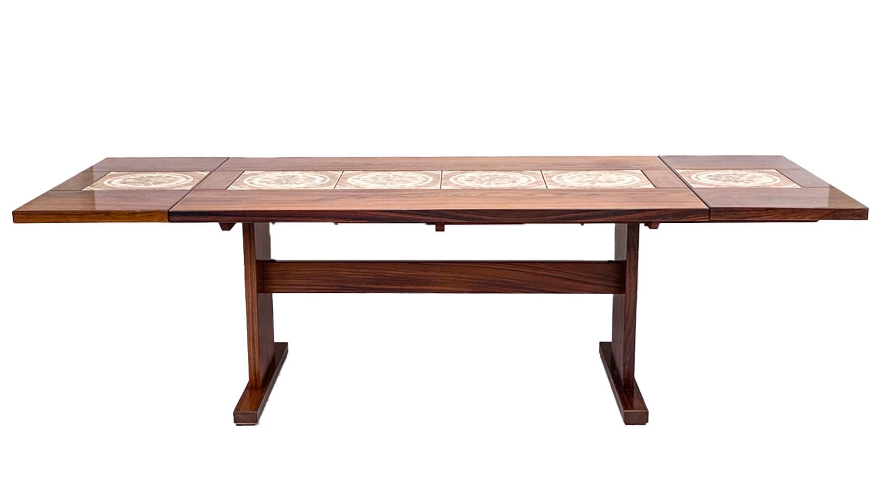 A beautiful Scandinavian modern dining table with handsome rosewood veneer and Ox Art inset abstract design ceramic tiles. A fabulous trestle style base and two 17.5
