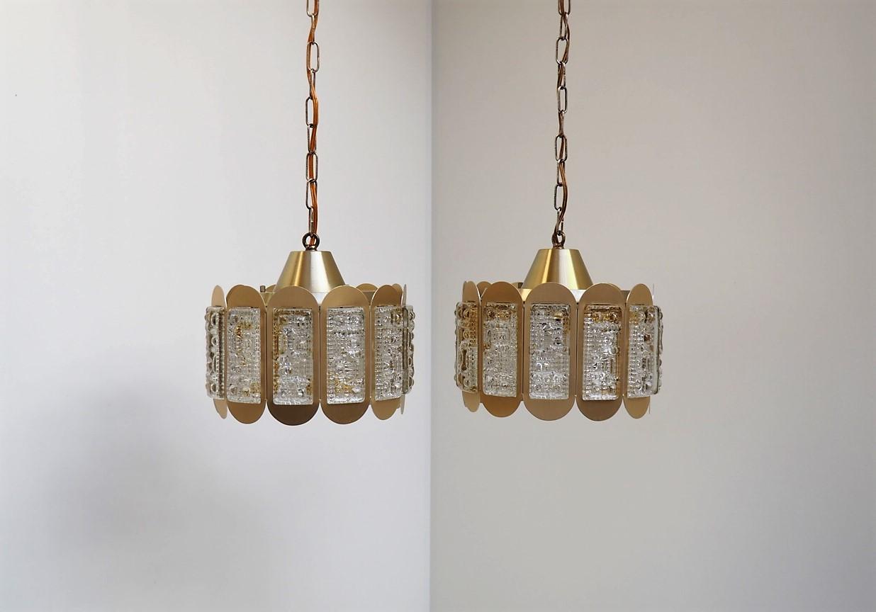 Danish pair of brass colored pendants decorated with thick rectangular glass pieces. They are made by the Danish company Vitrika in the 1960´s.

The glass pieces have a really nice pattern that makes the light shine so amazing from this pendant.